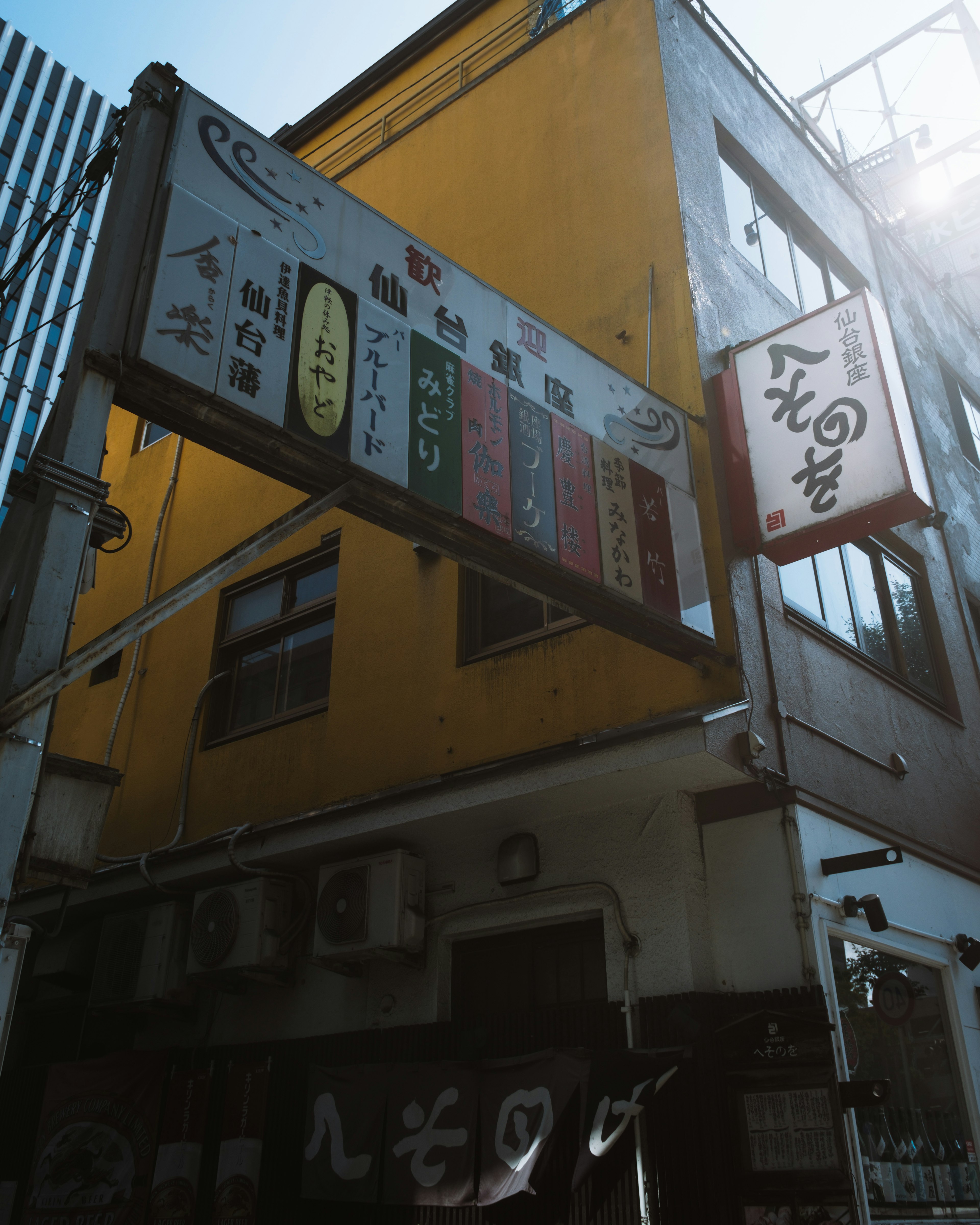 Street view featuring a yellow building with colorful signage