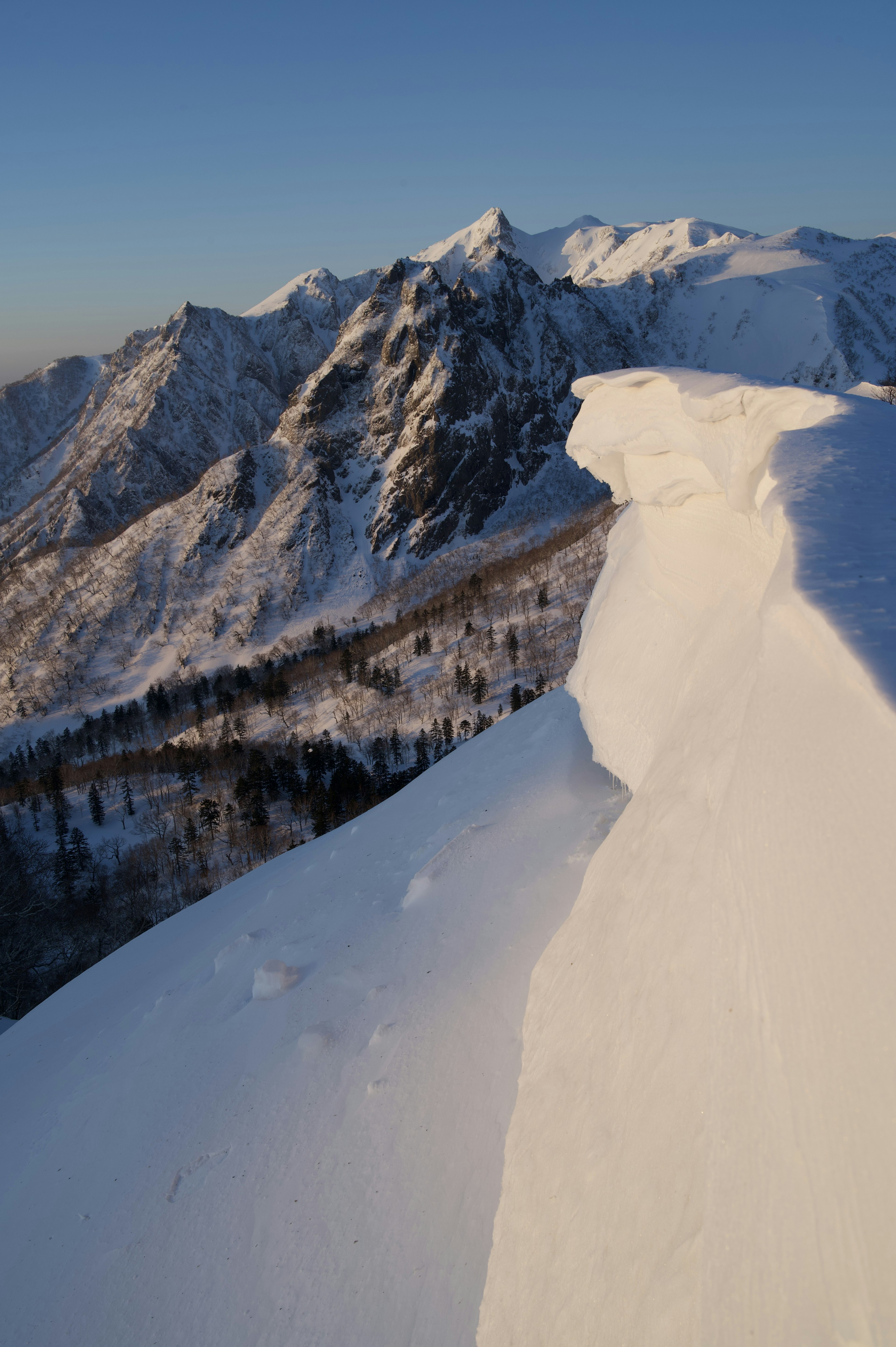 Vue depuis le sommet enneigé de la montagne avec ciel bleu clair