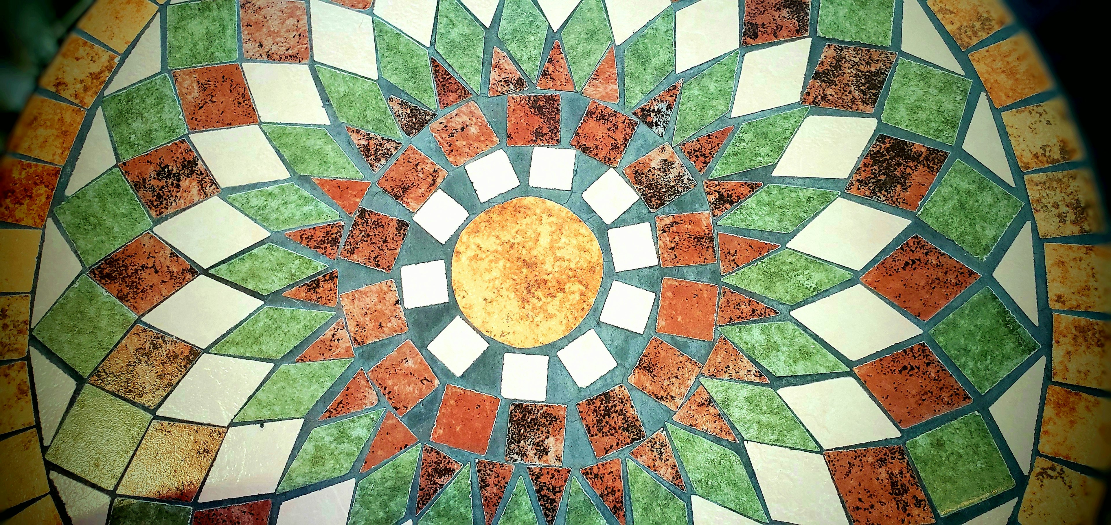 Colorful mosaic design in circular pattern with a central yellow circle