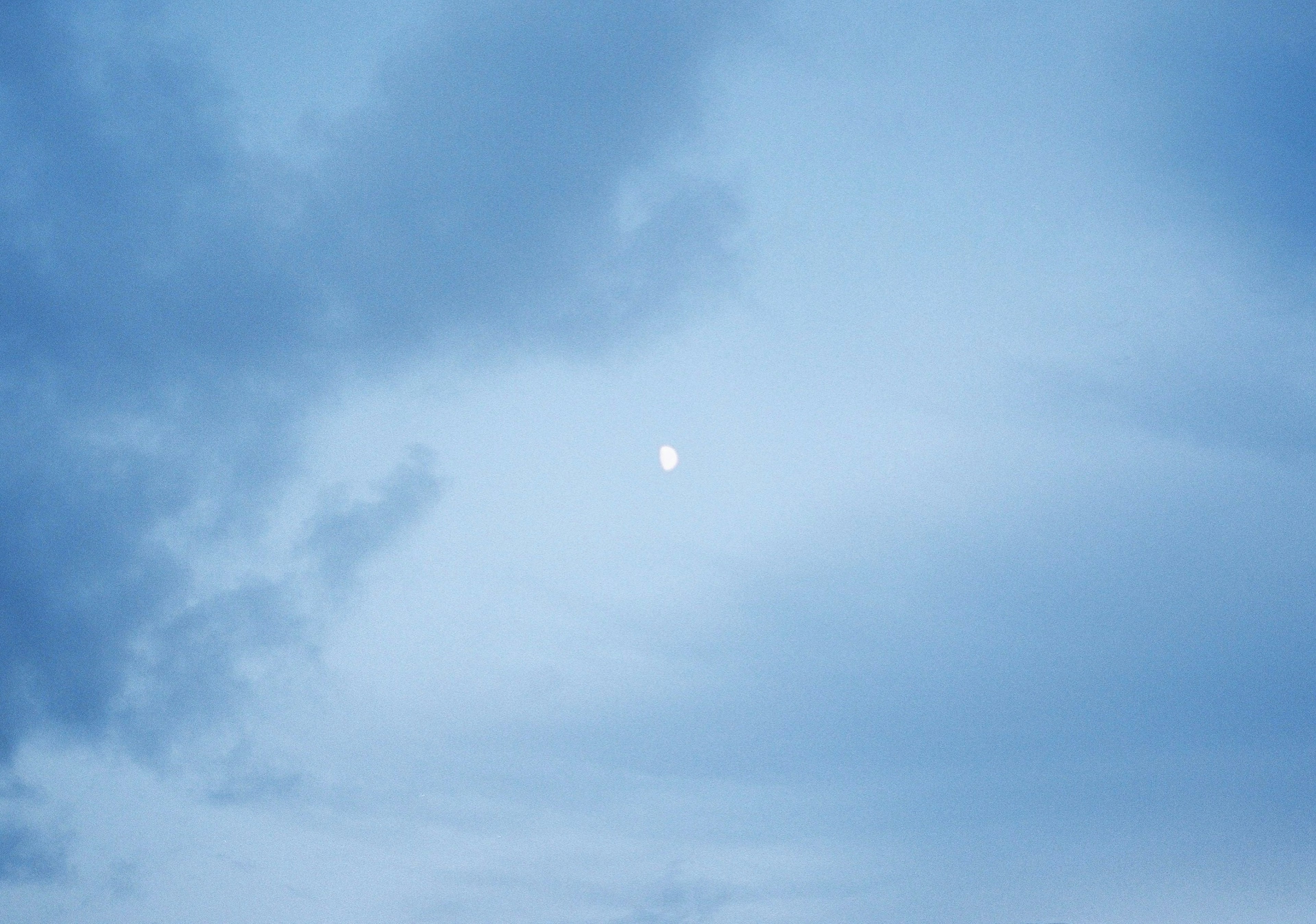 青い空に浮かぶ月と雲