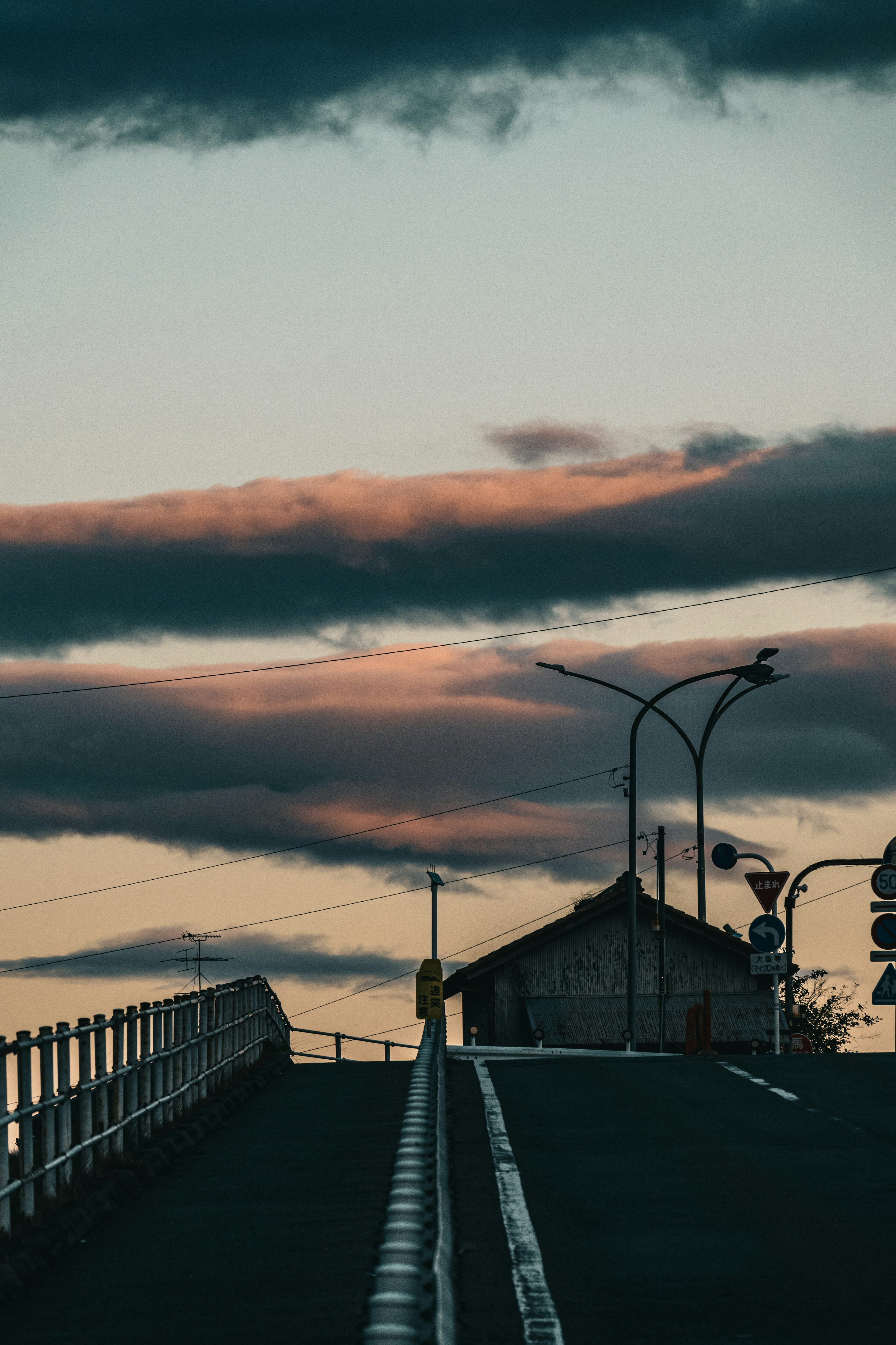 夕暮れの空と道路の風景に小さな家が見える