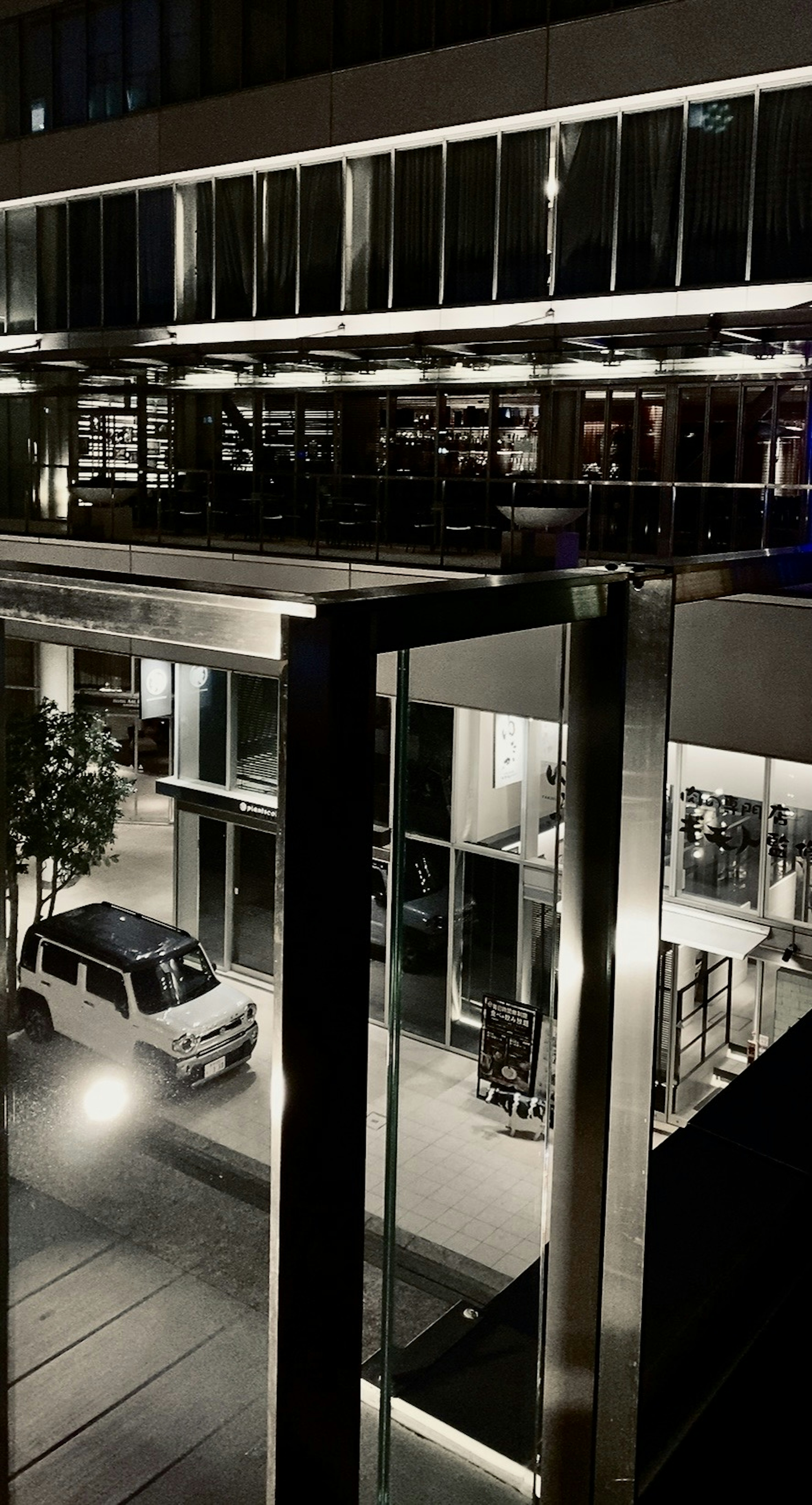 Modern building and car in a nighttime urban setting