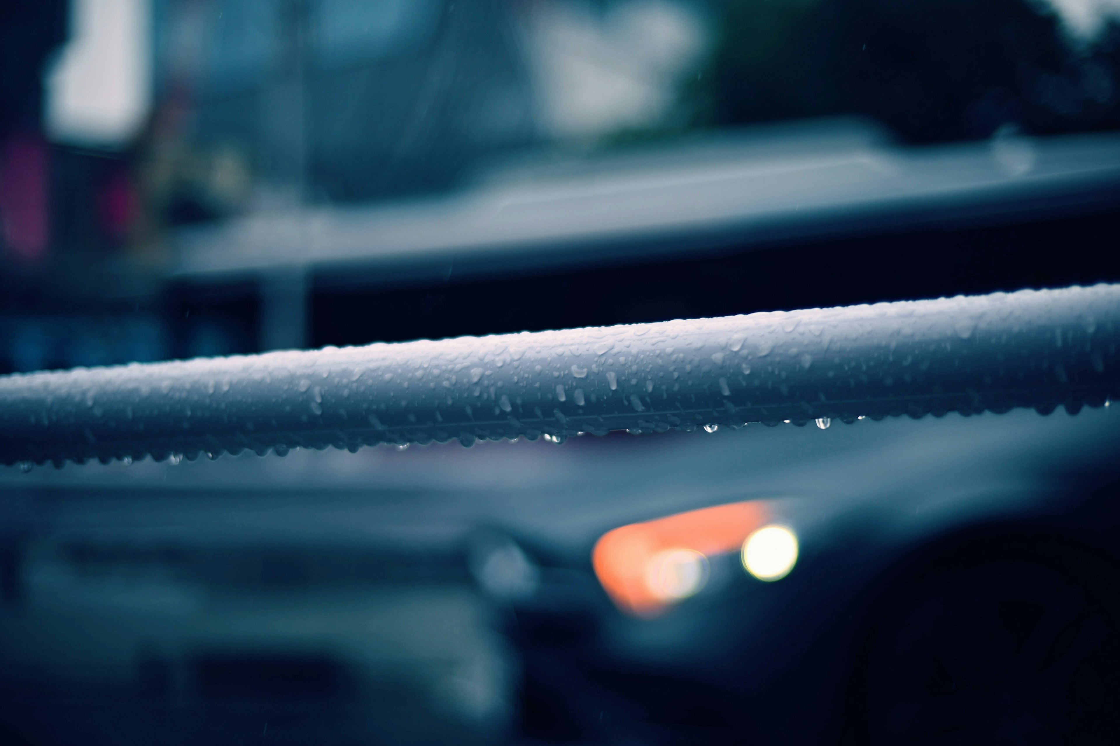 雨に濡れた手すりとぼやけた車のヘッドライト