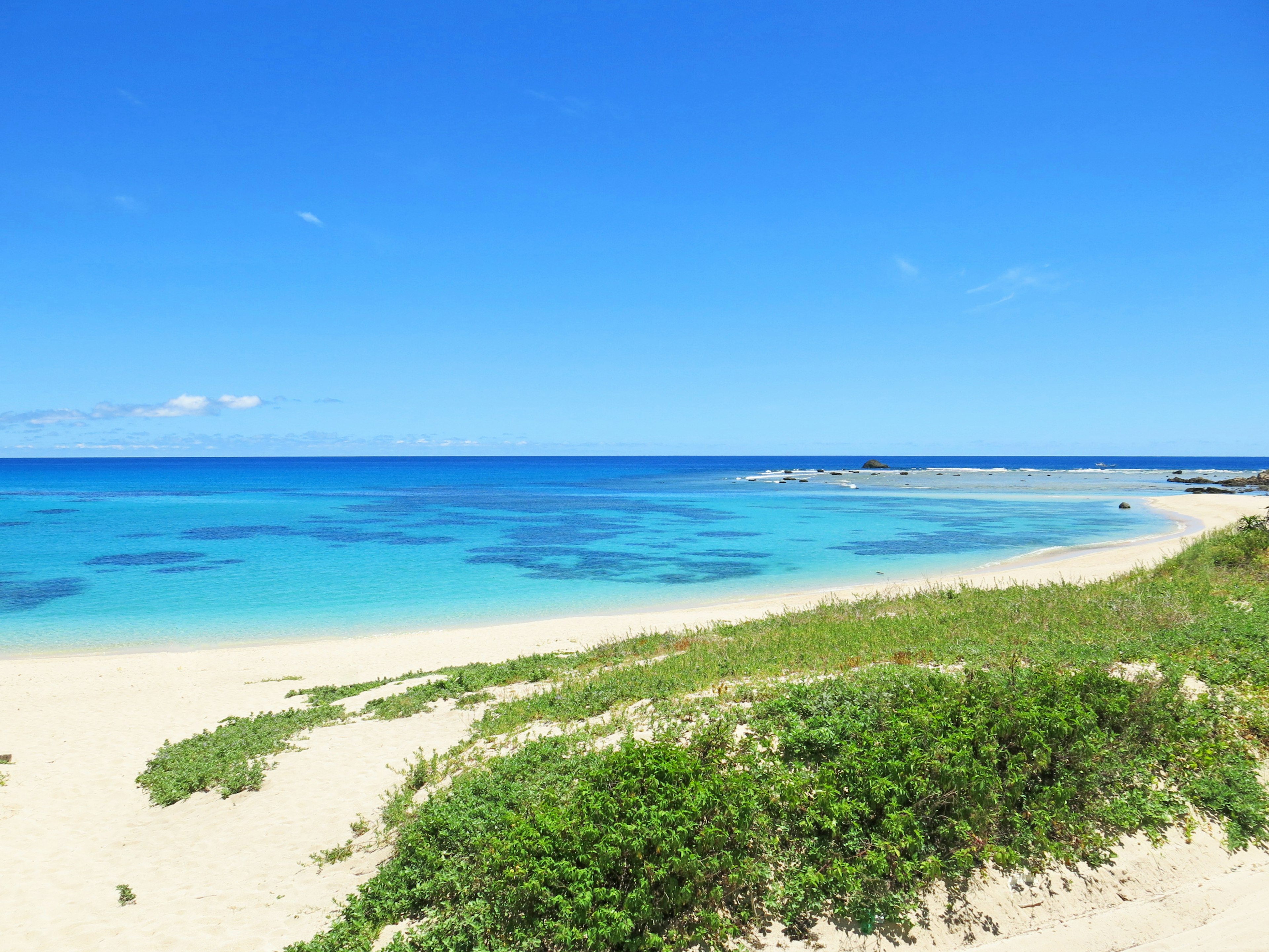 Pantai indah dengan lautan biru dan pasir putih