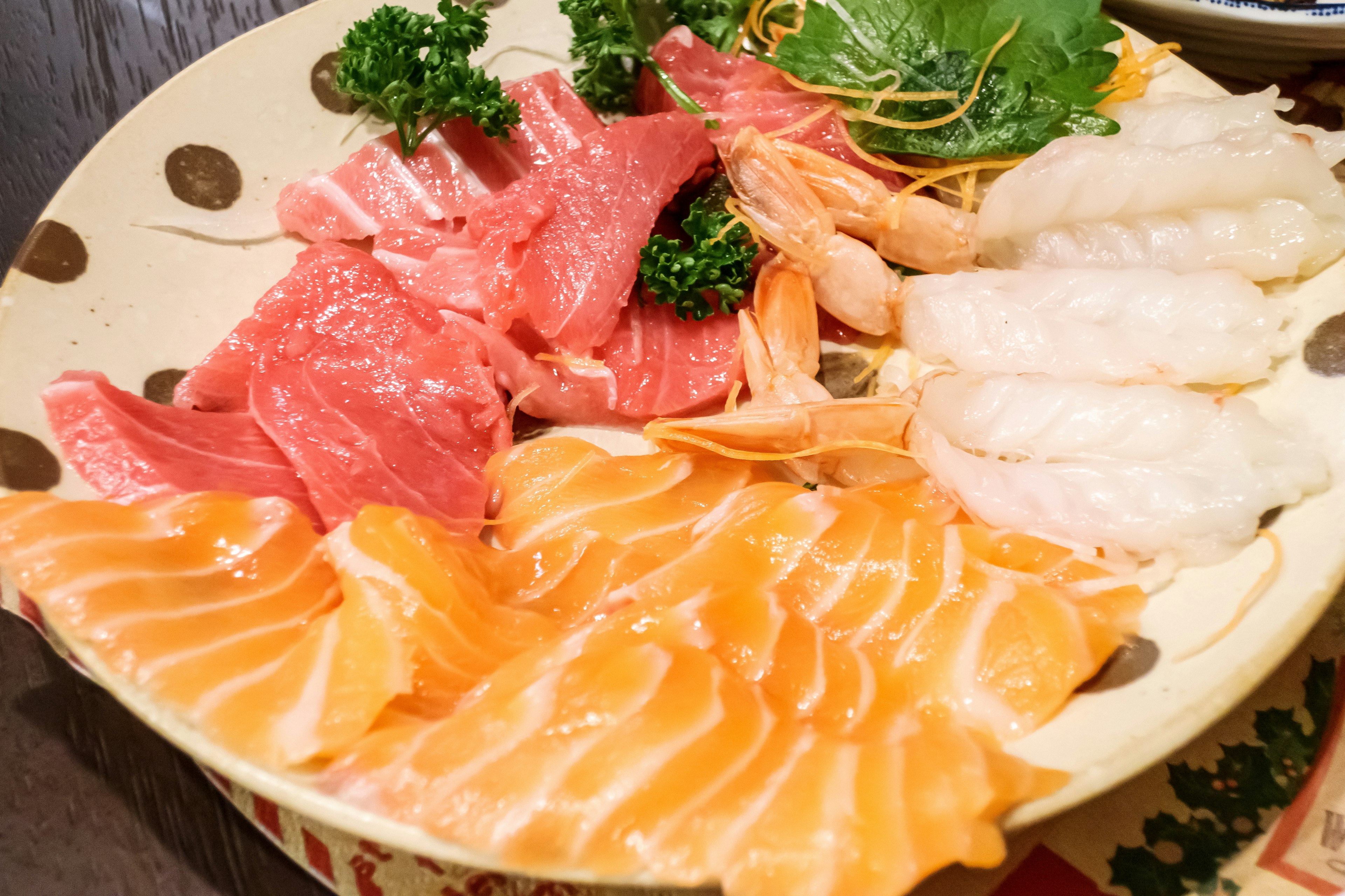 Piatto di sashimi vibrante con vari pesci colorati disposti su un piatto