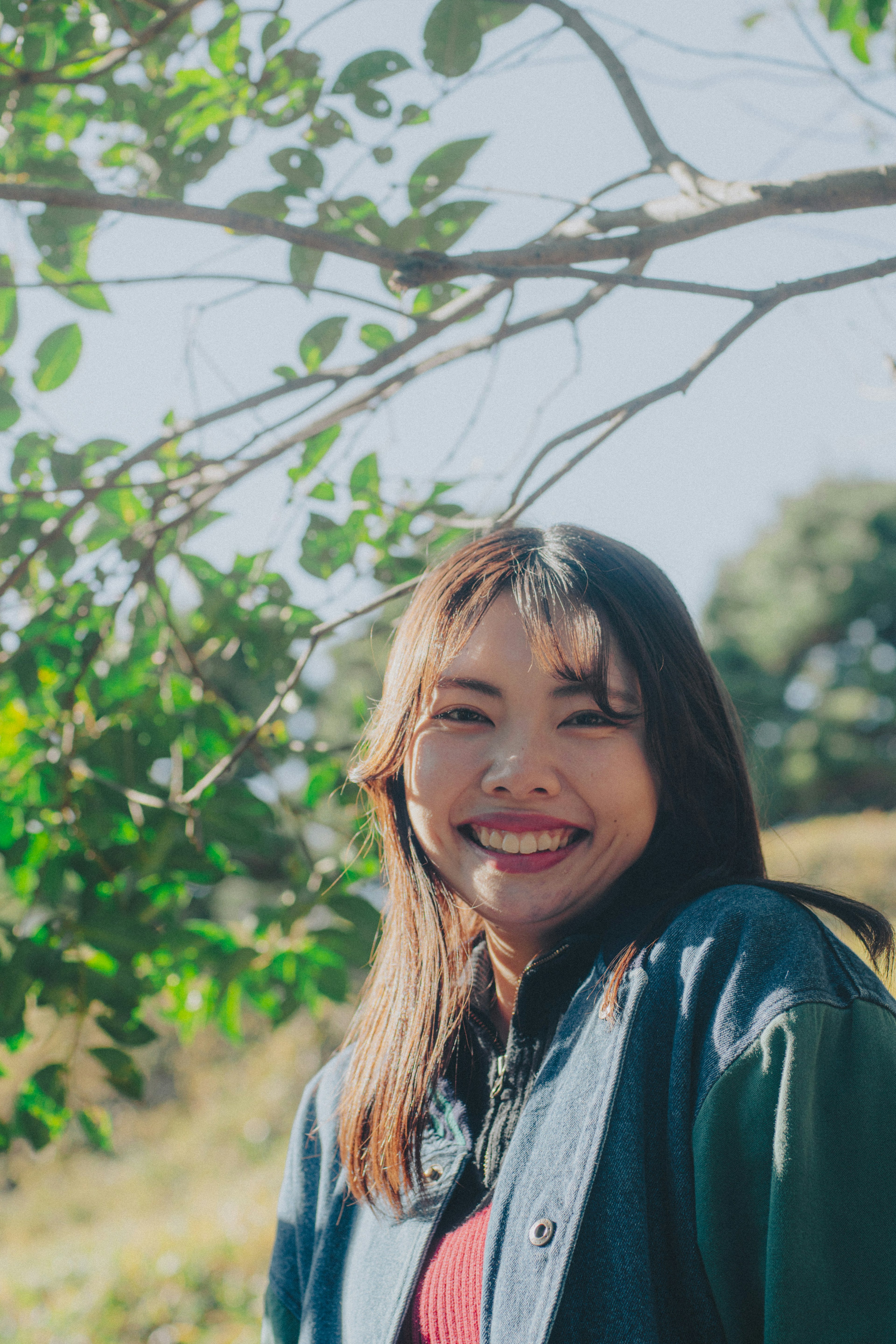 Retrato de una mujer sonriente frente a hojas verdes