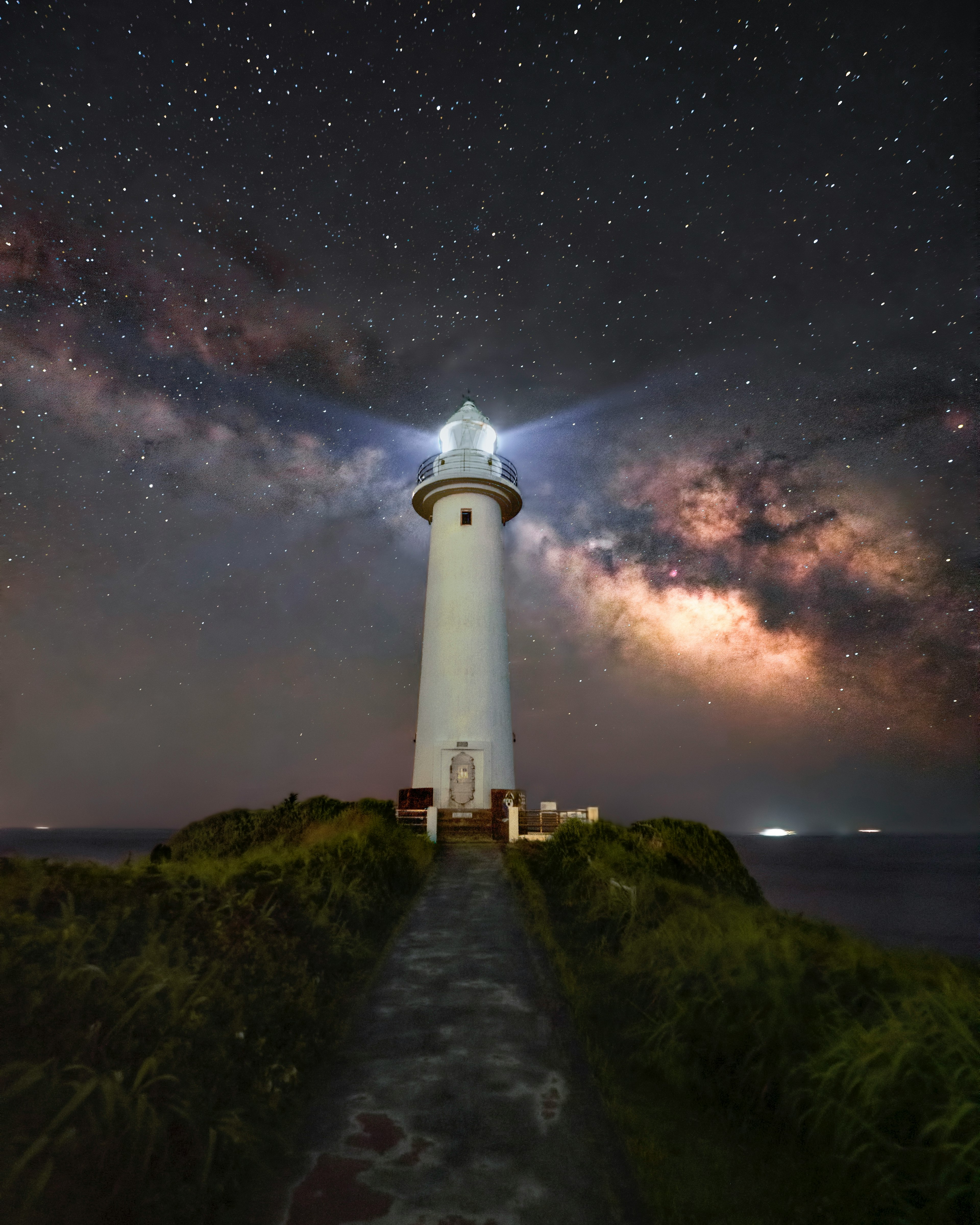 Faro iluminado bajo un cielo estrellado con la Vía Láctea visible