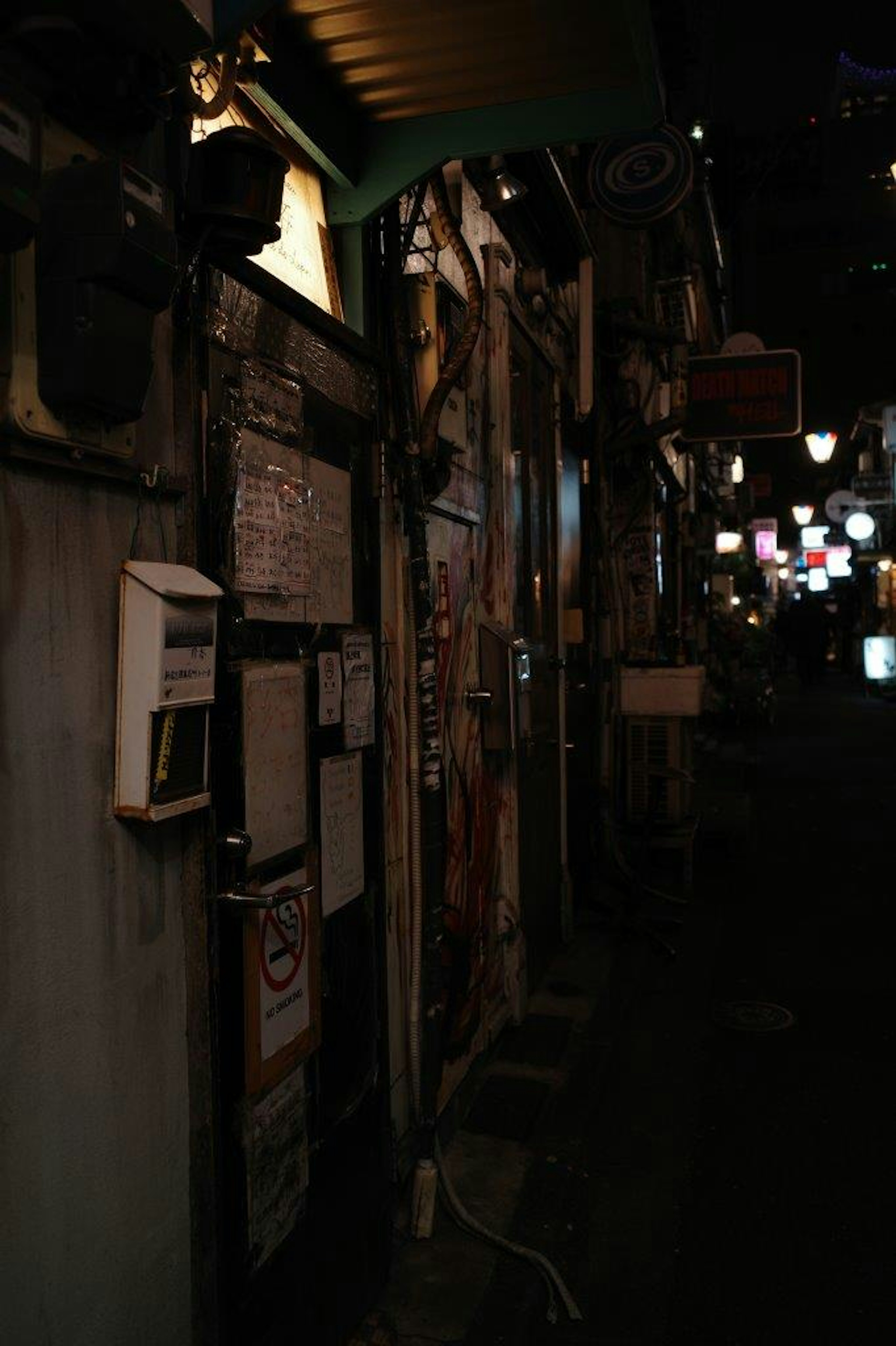 暗い路地に並ぶ古い建物と提灯のある風景