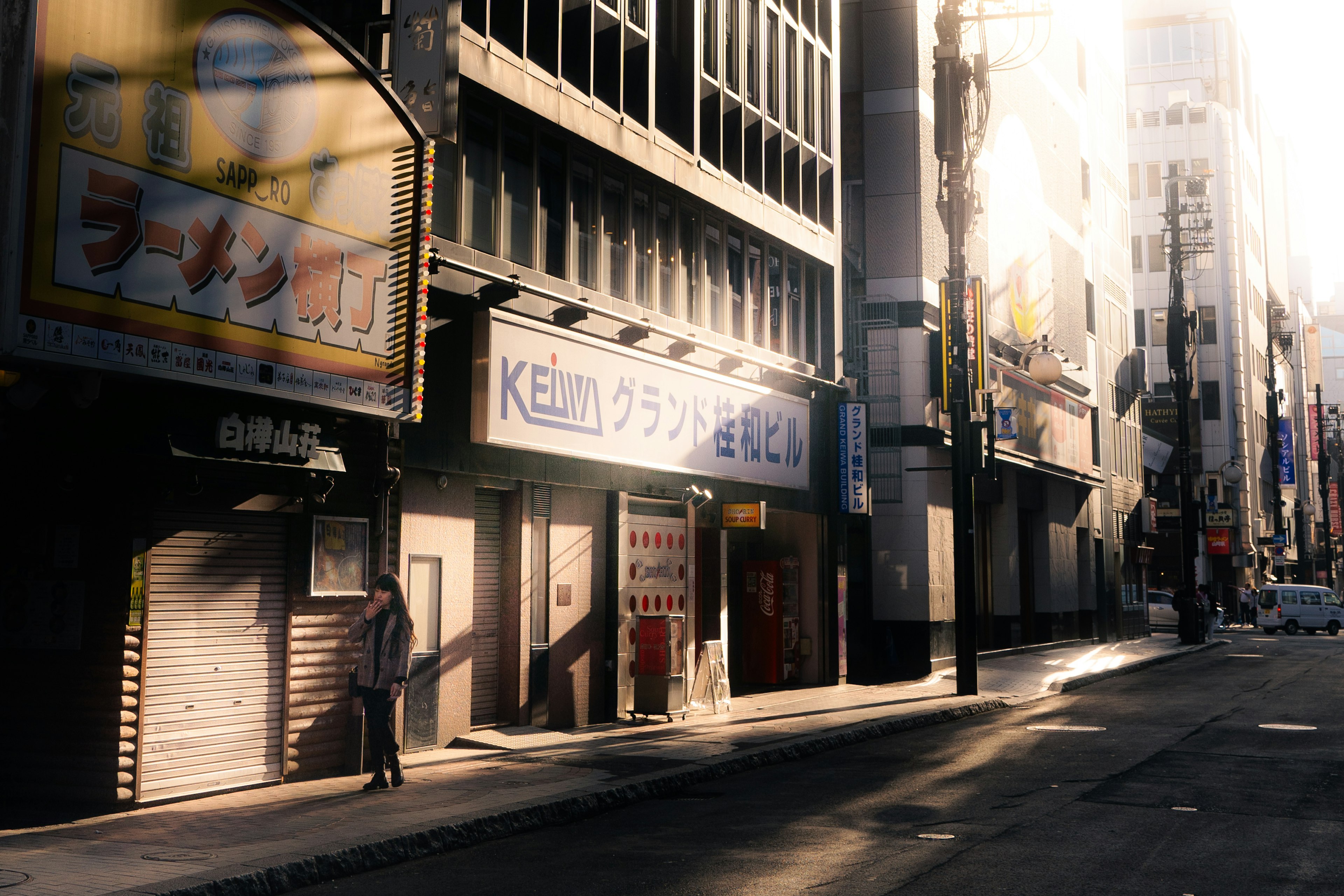 Quiet street scene with storefronts illuminated by morning light