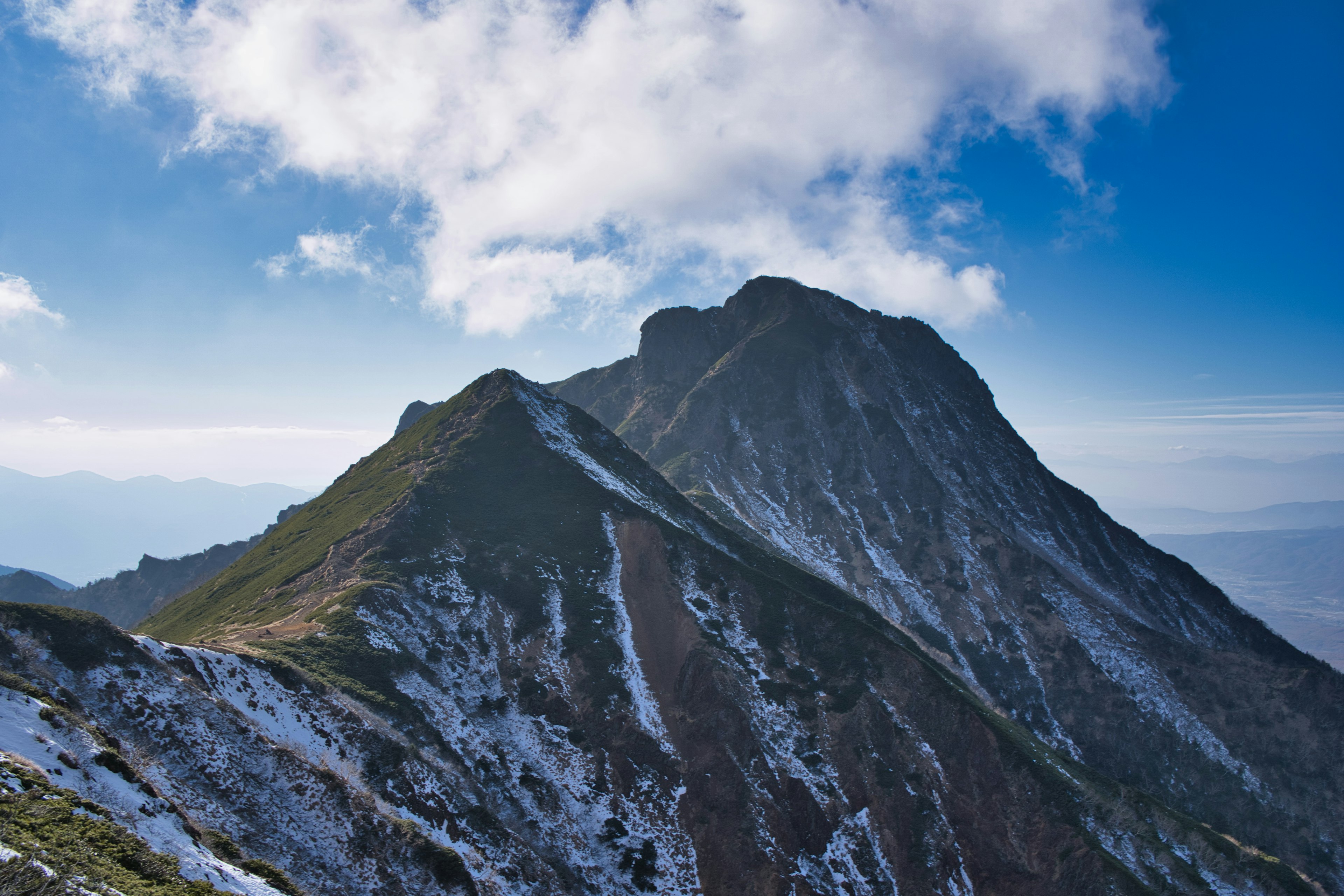 Pemandangan gunung bersalju dengan langit biru dan awan