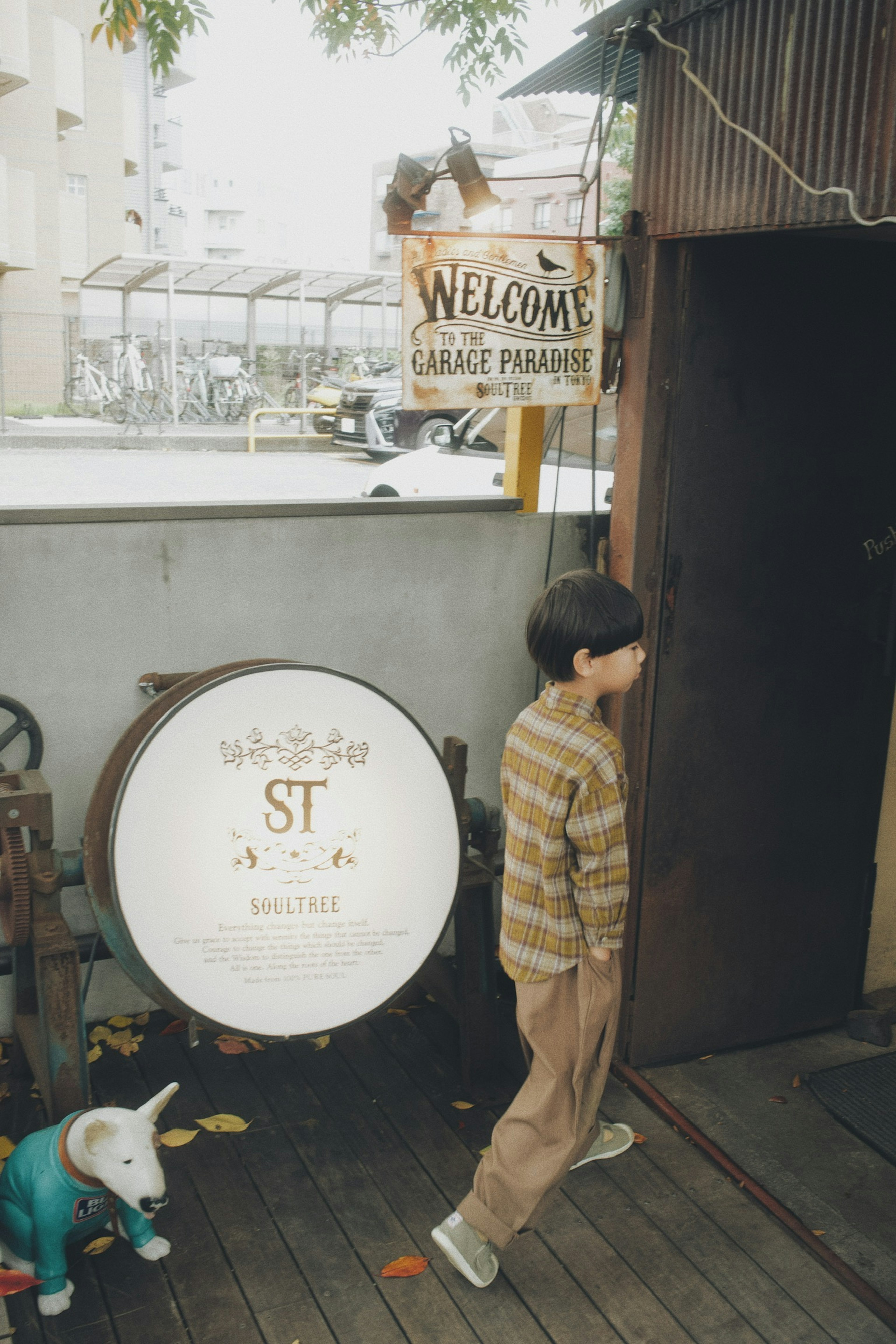 A child wearing a striped shirt standing in front of a casual entrance