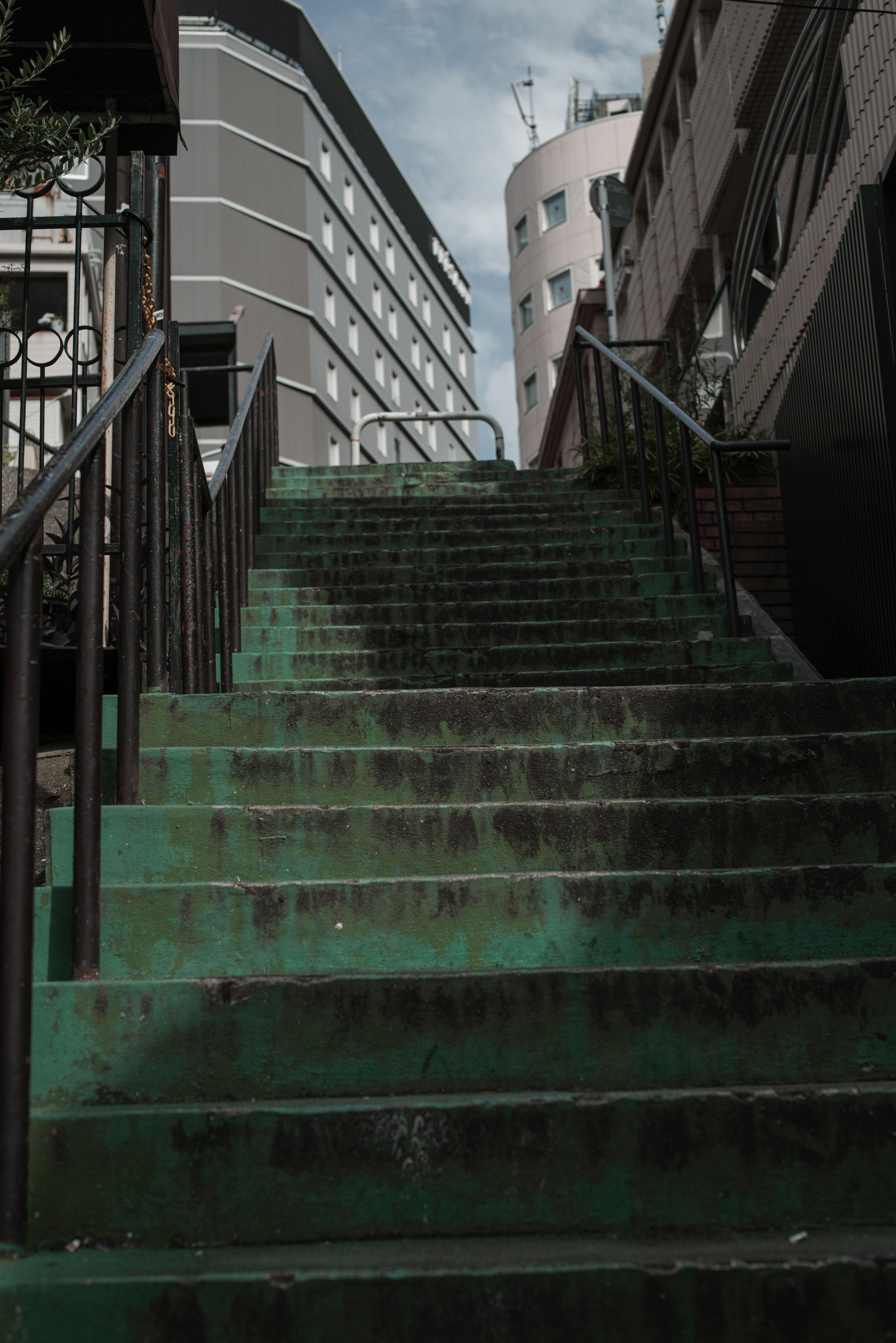 Städtische Szene mit grünen Treppen und umliegenden Gebäuden