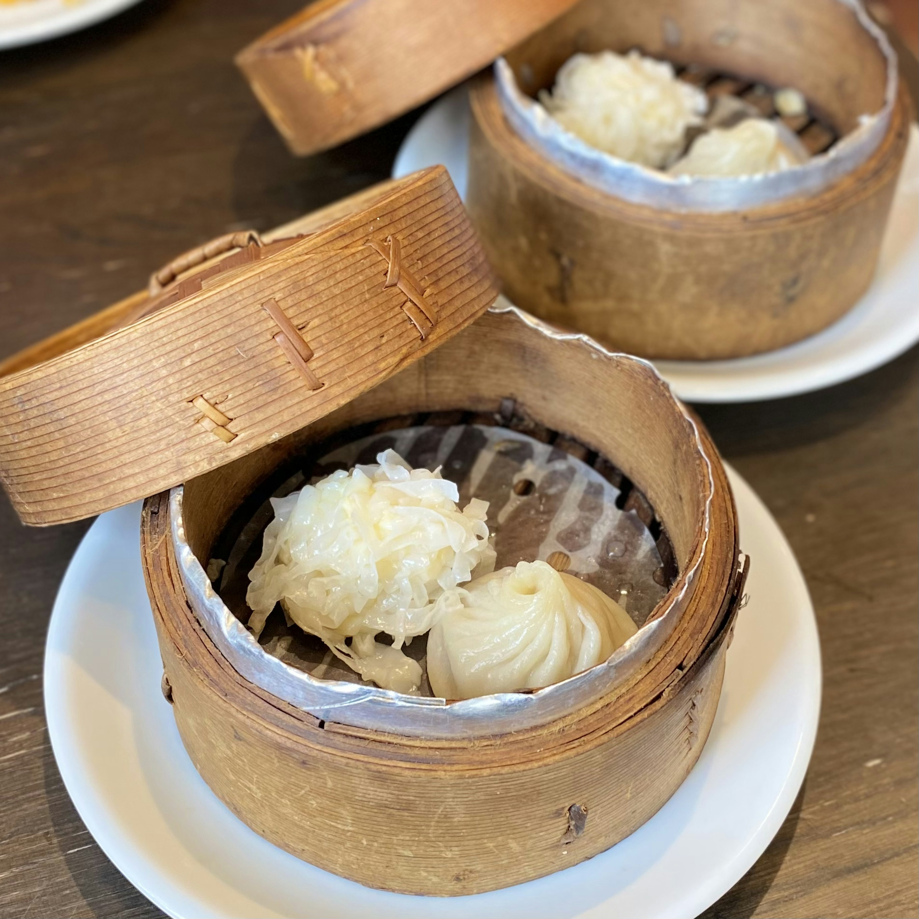 A bamboo steamer containing a variety of dim sum dishes