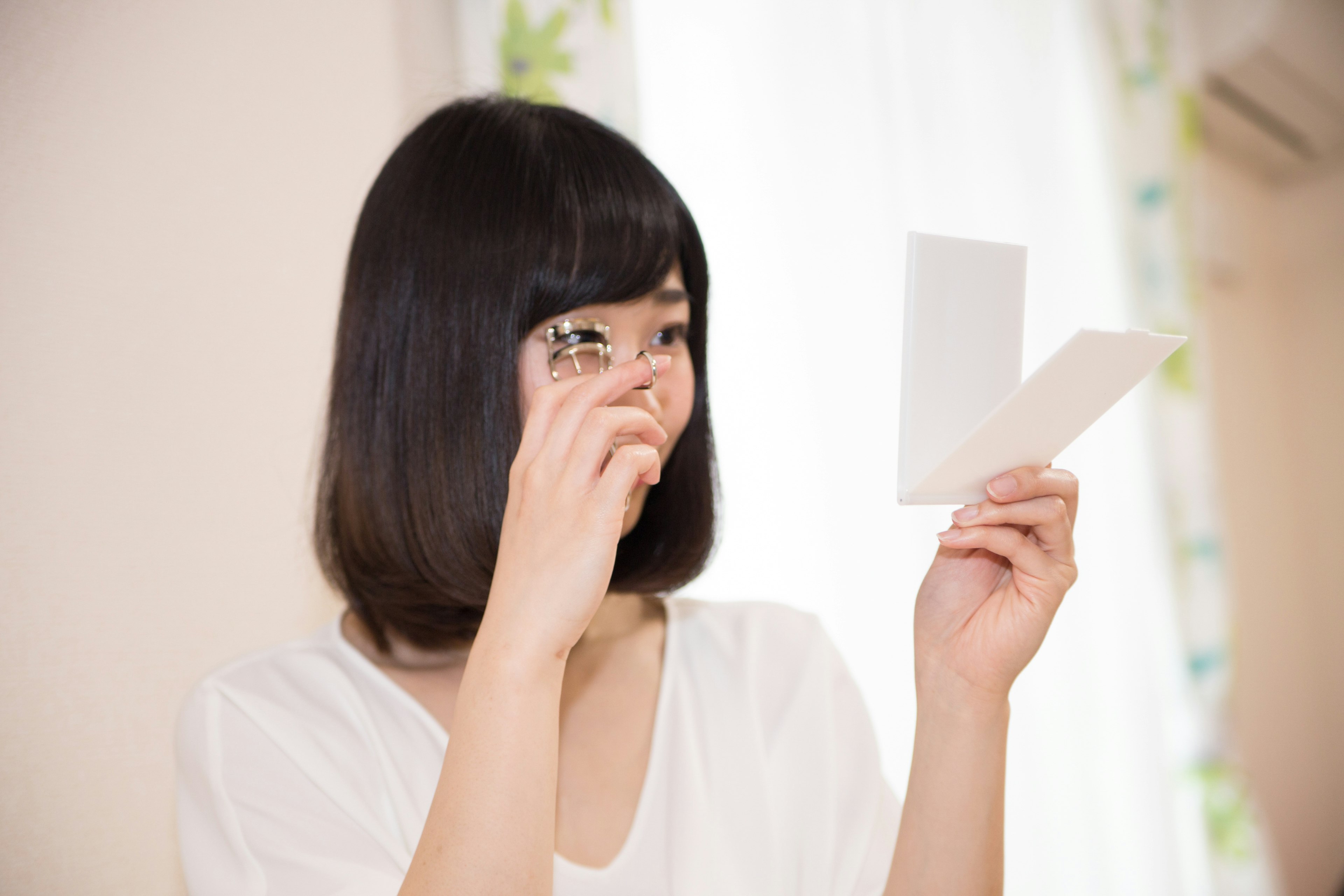 A woman smiling while holding a white card