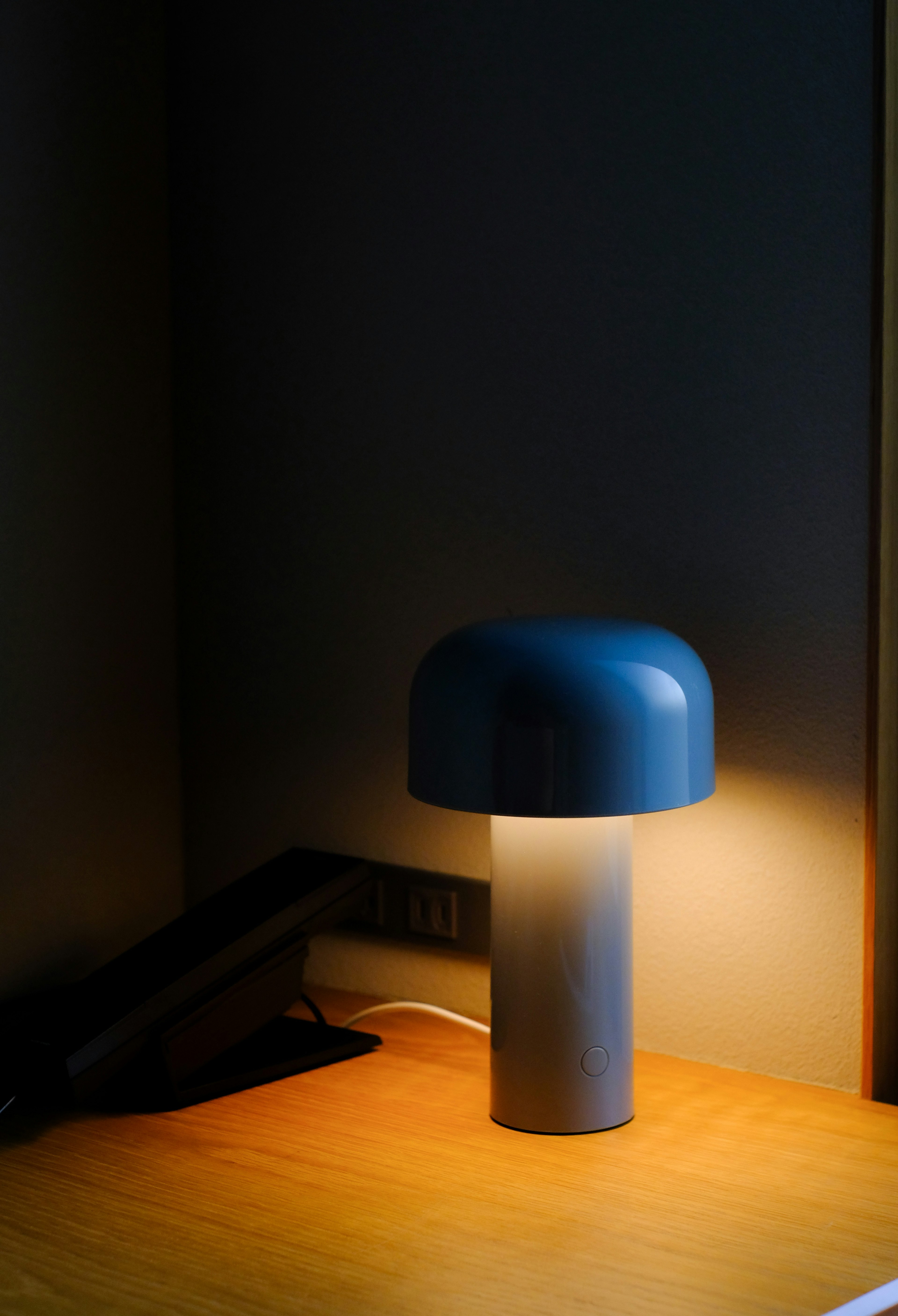 A blue lamp on a wooden table with warm light