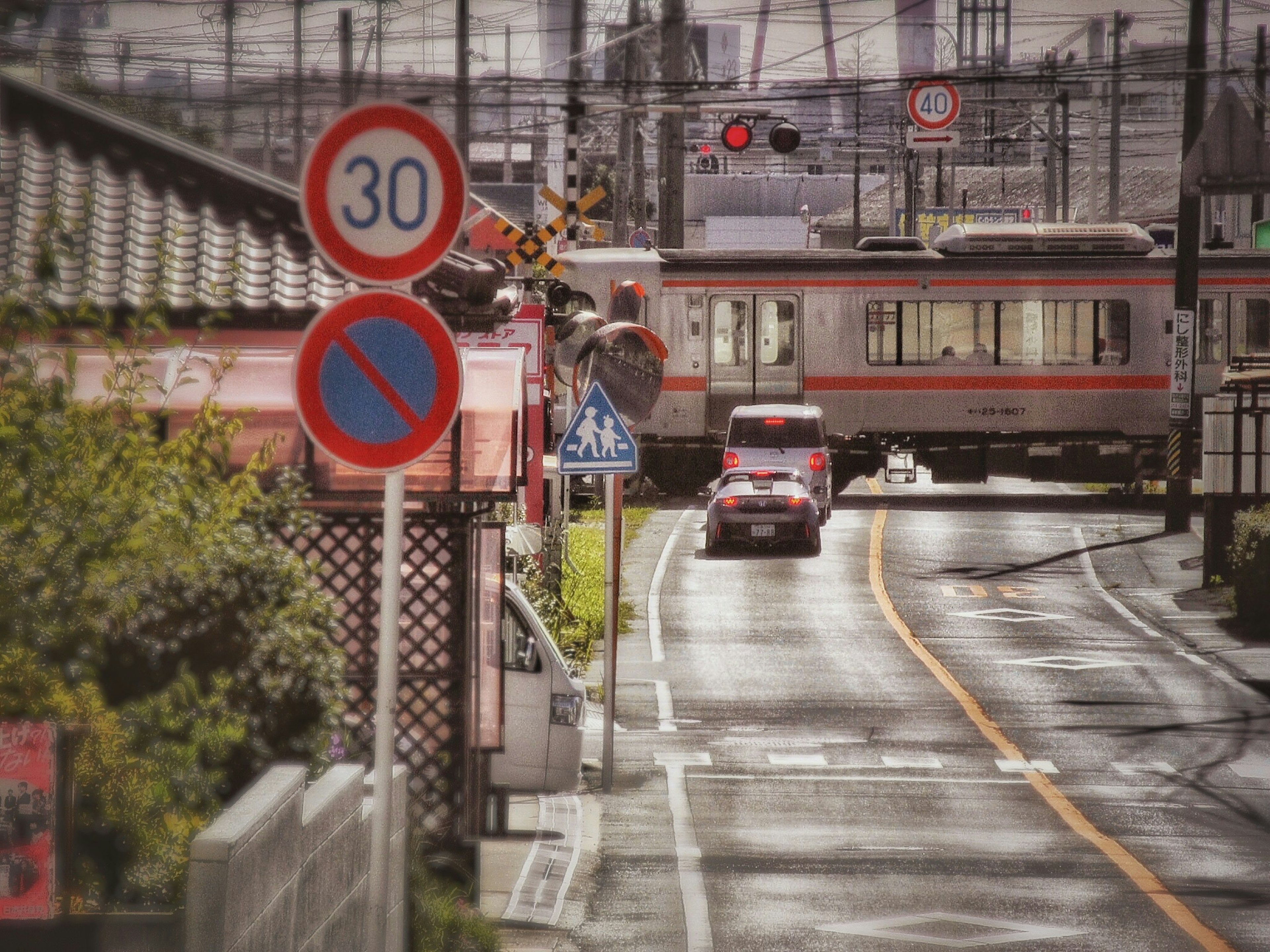 Tren cruzando una carretera con señales de tráfico