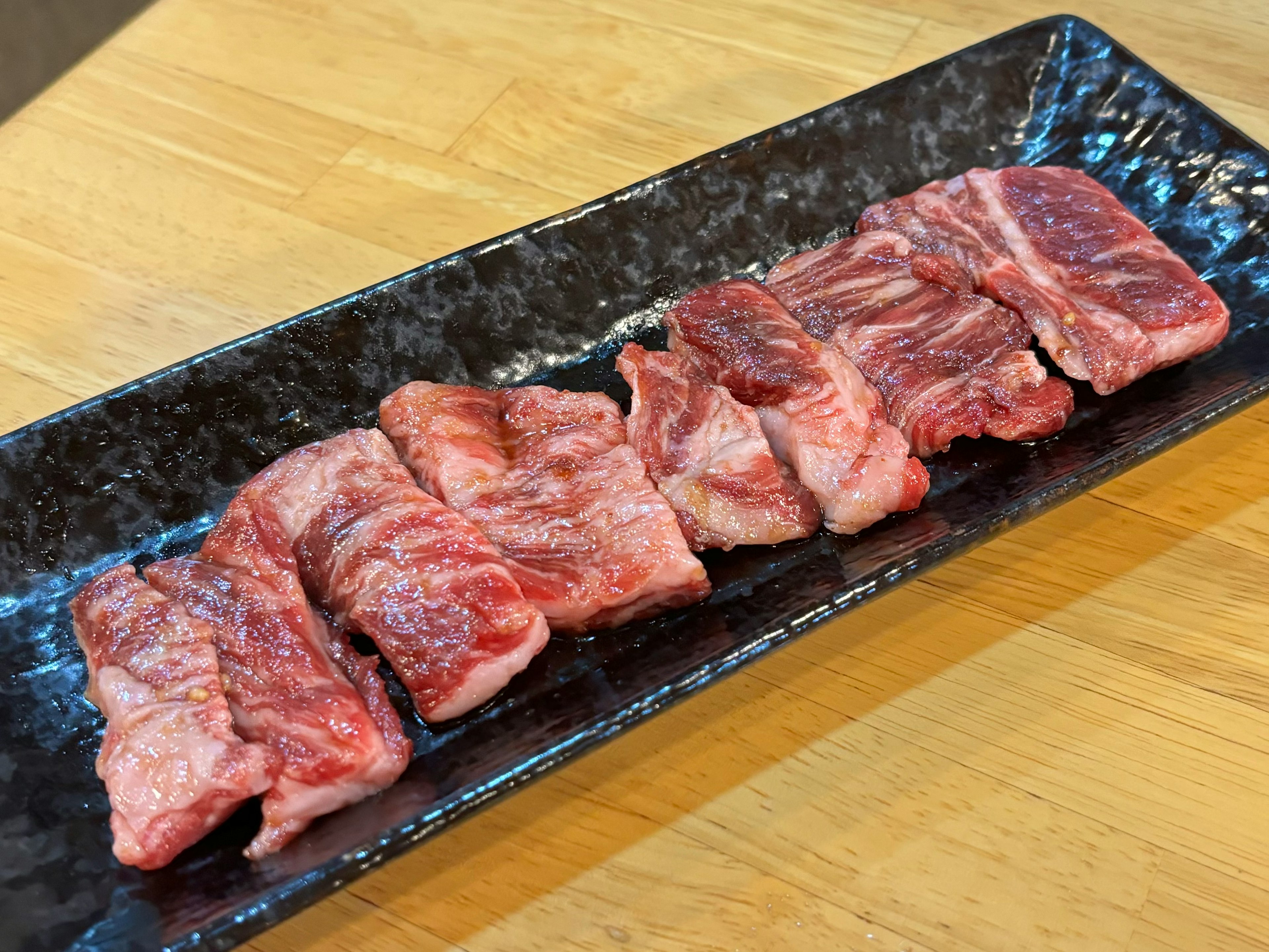 黒い皿に並べられた美味しそうな牛肉の切り身