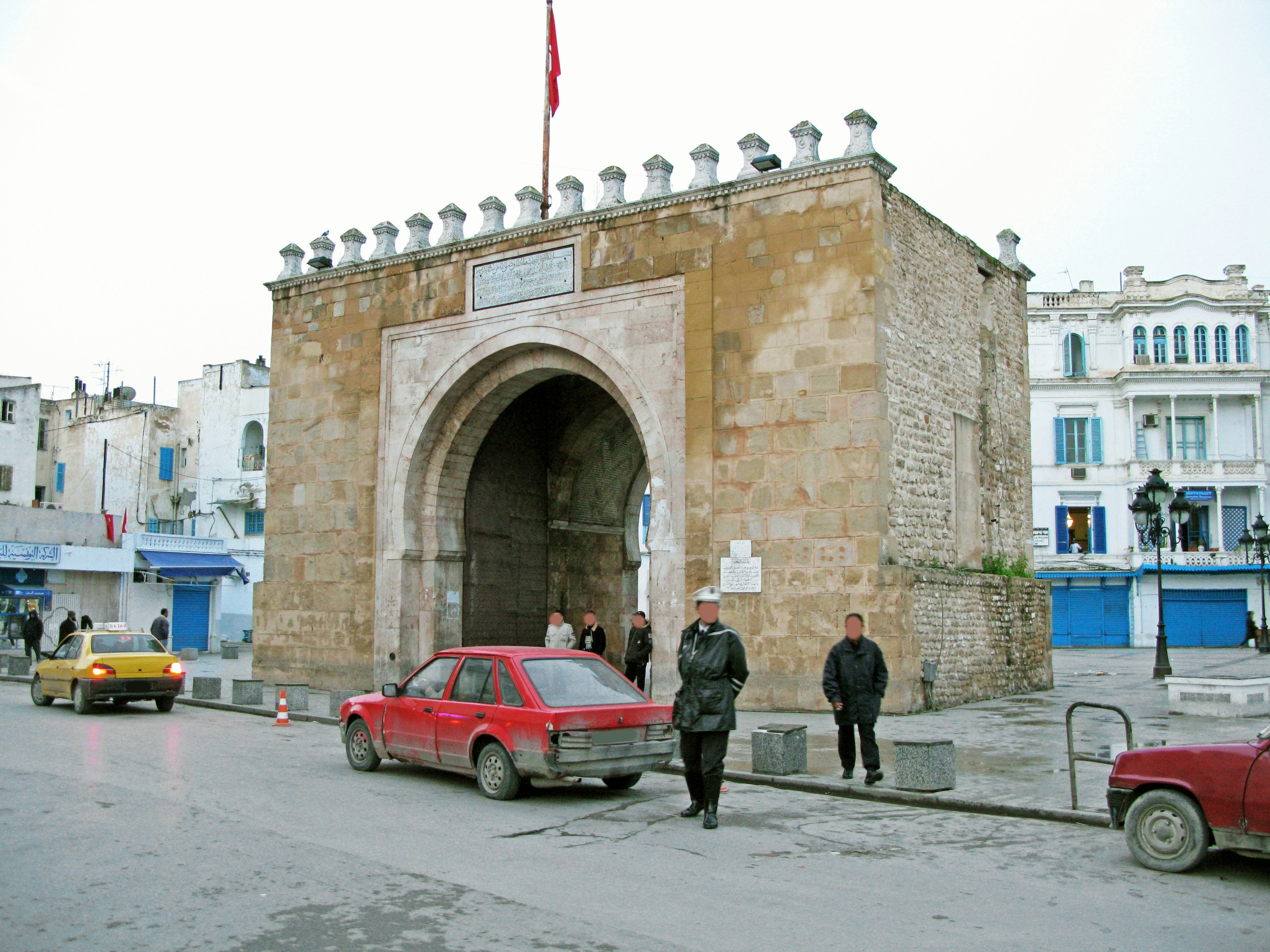 Historic archway with surrounding buildings in a street scene