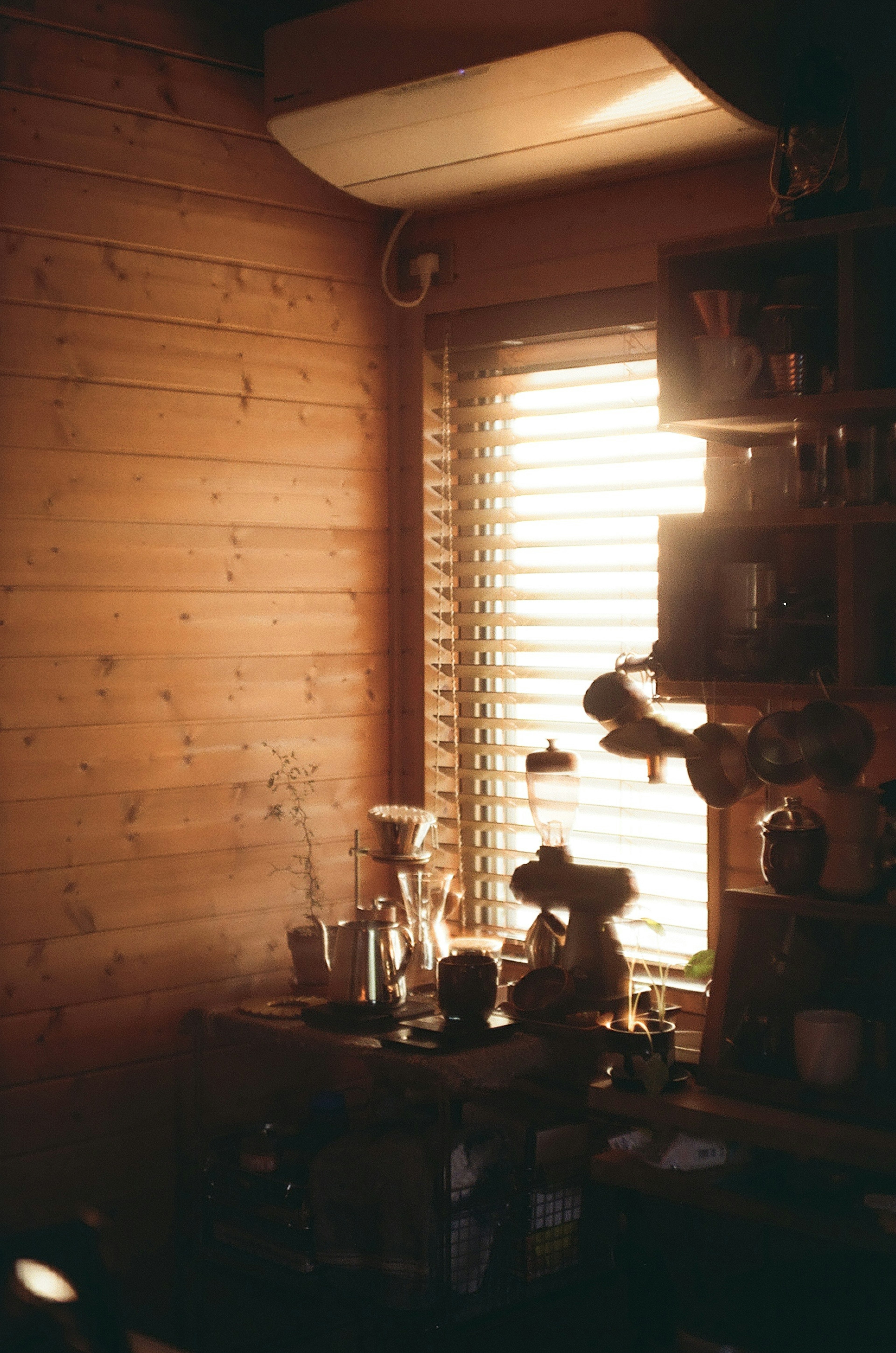 Gemütliche Ecke eines Innenraums mit Holzwänden und sanftem Licht von einem Fenster