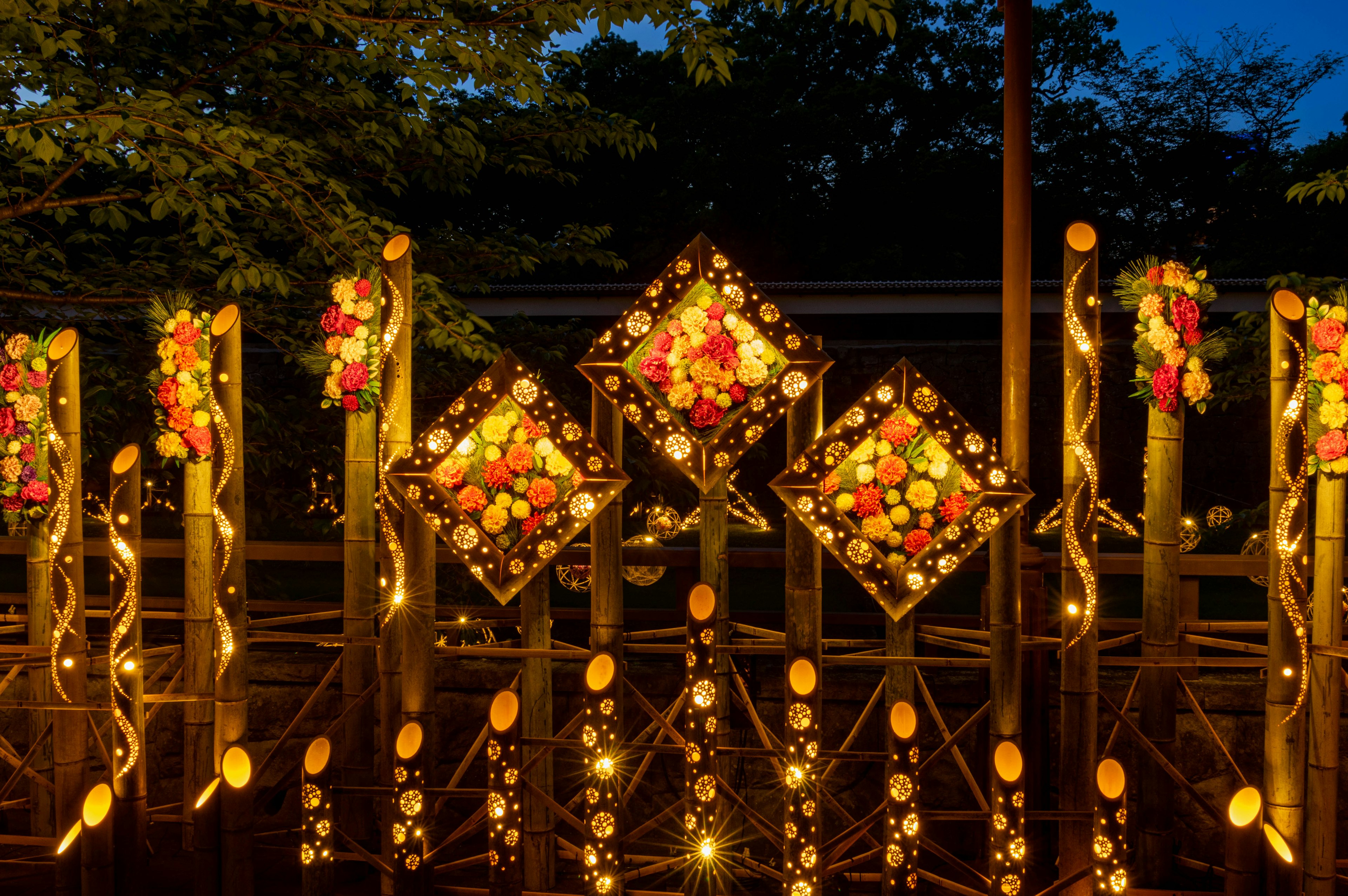 Hermoso arco decorado con flores coloridas y luces por la noche