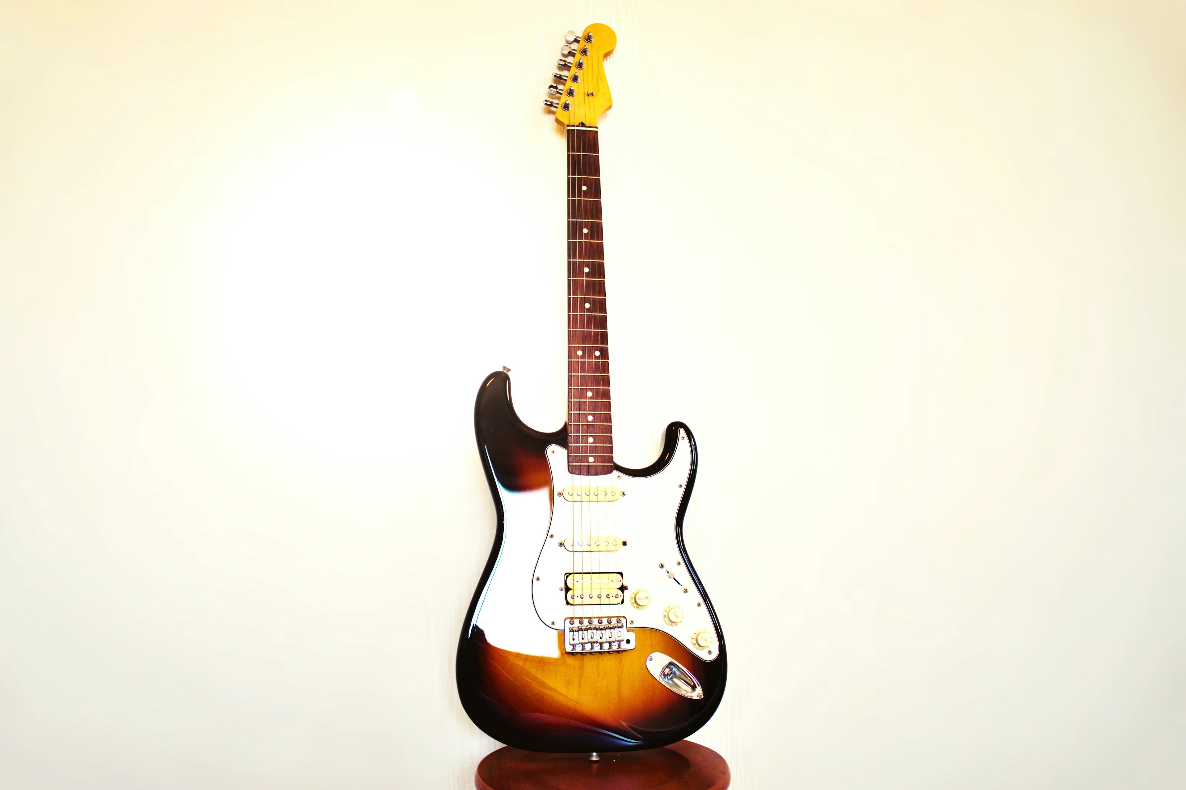 Electric Stratocaster guitar standing against a white background