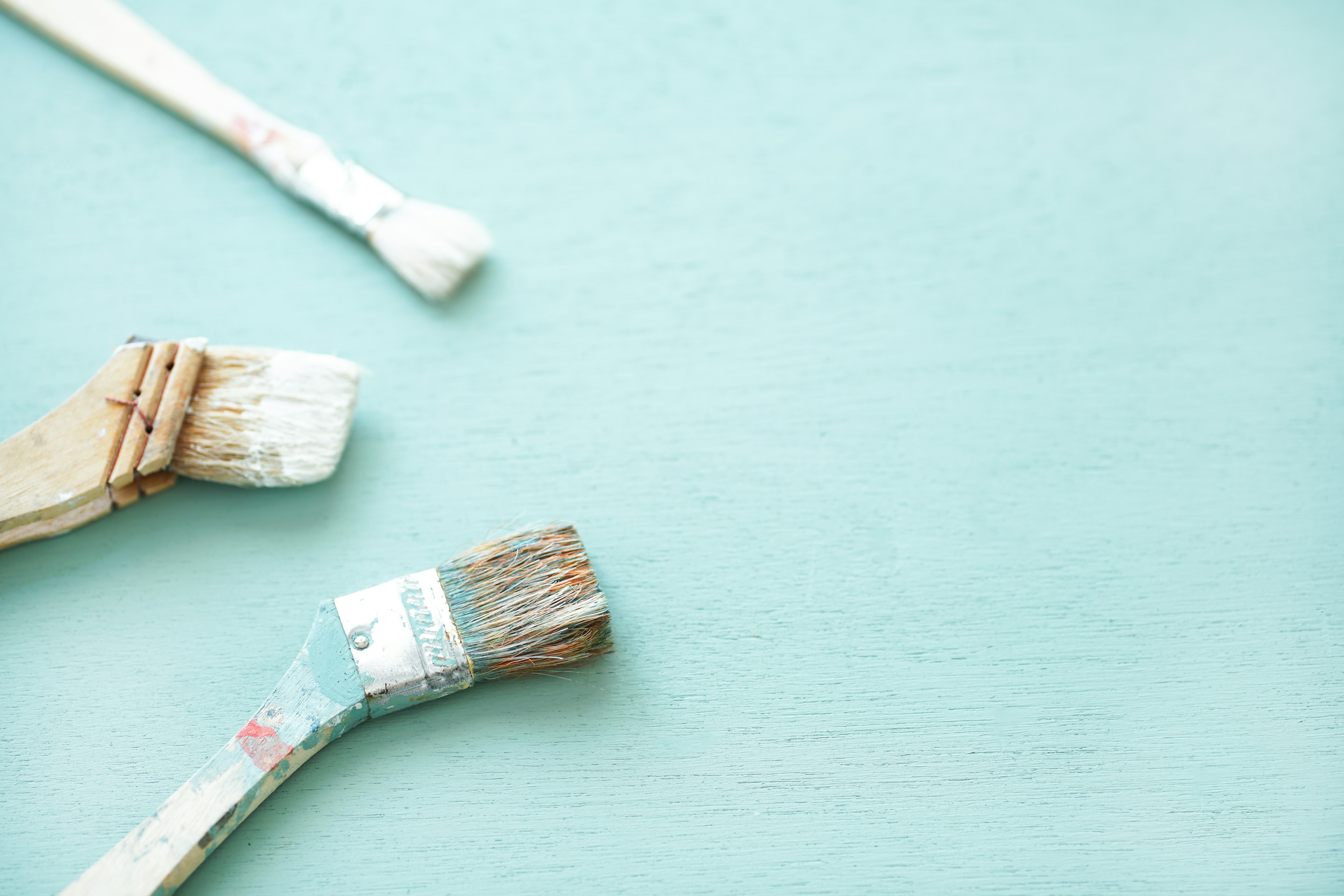 Different paint brushes on a blue background