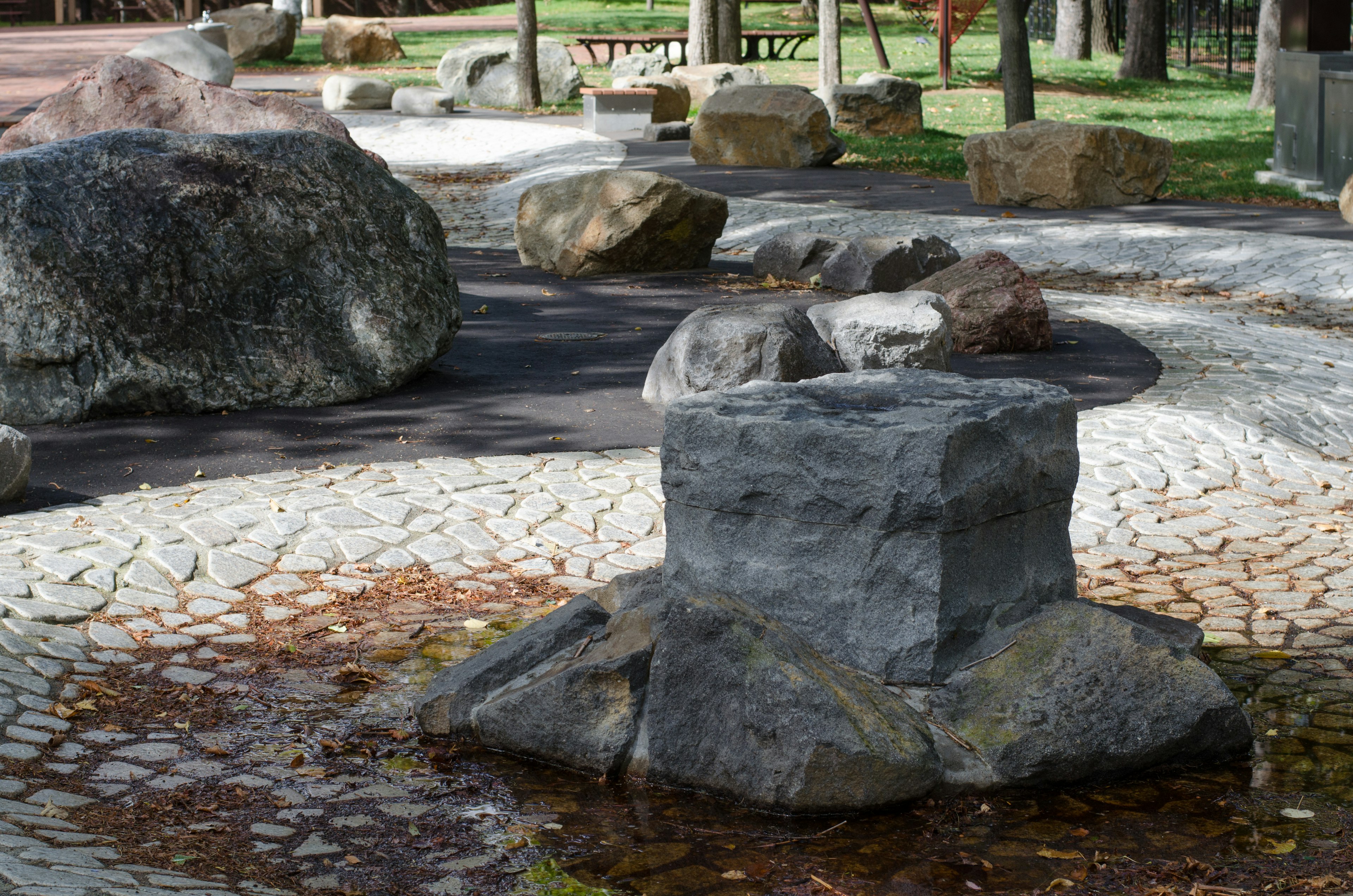 Parque con esculturas de piedra y camino pavimentado