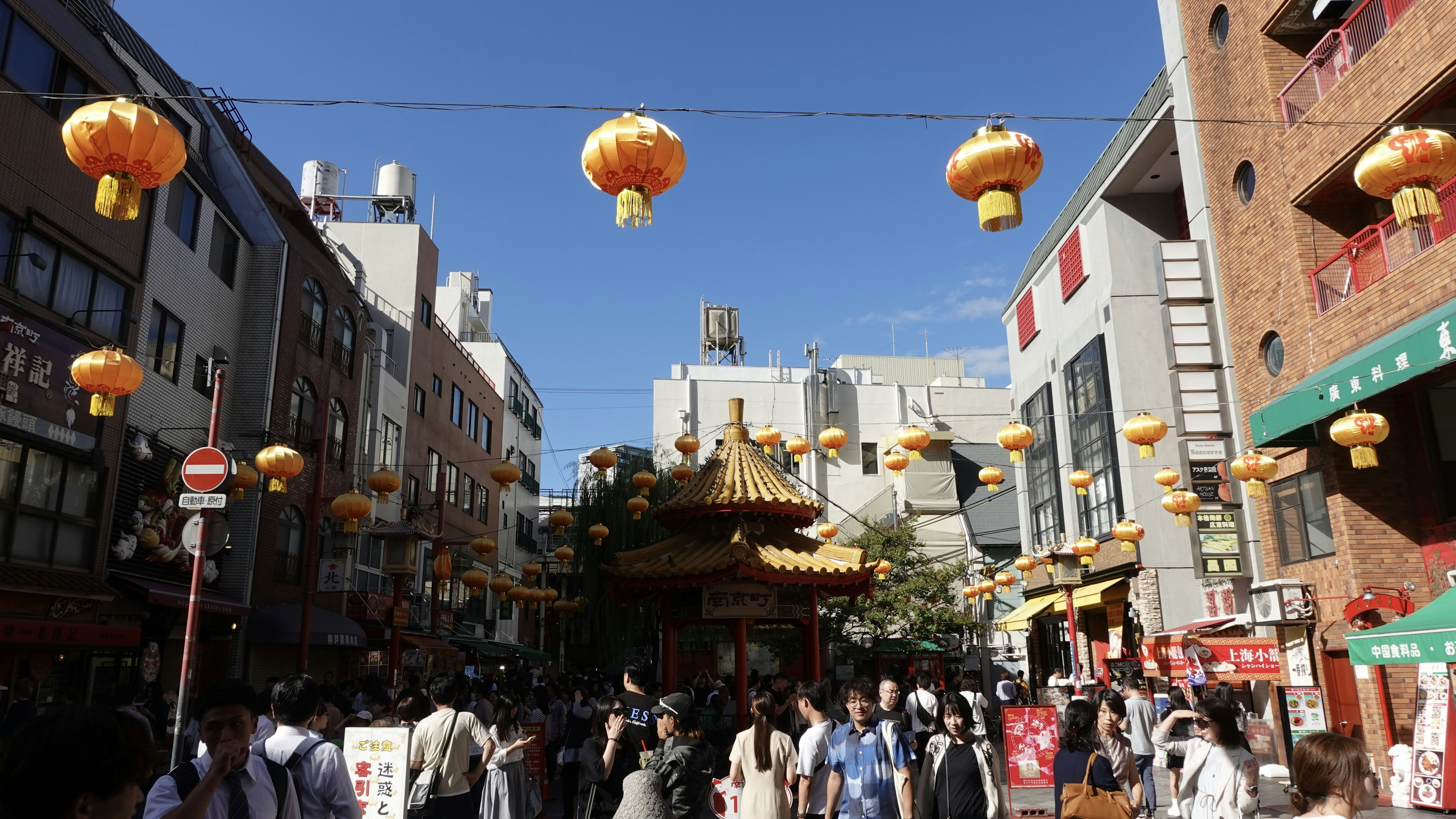 Busy street in Chinatown decorated with orange lanterns and crowds of people