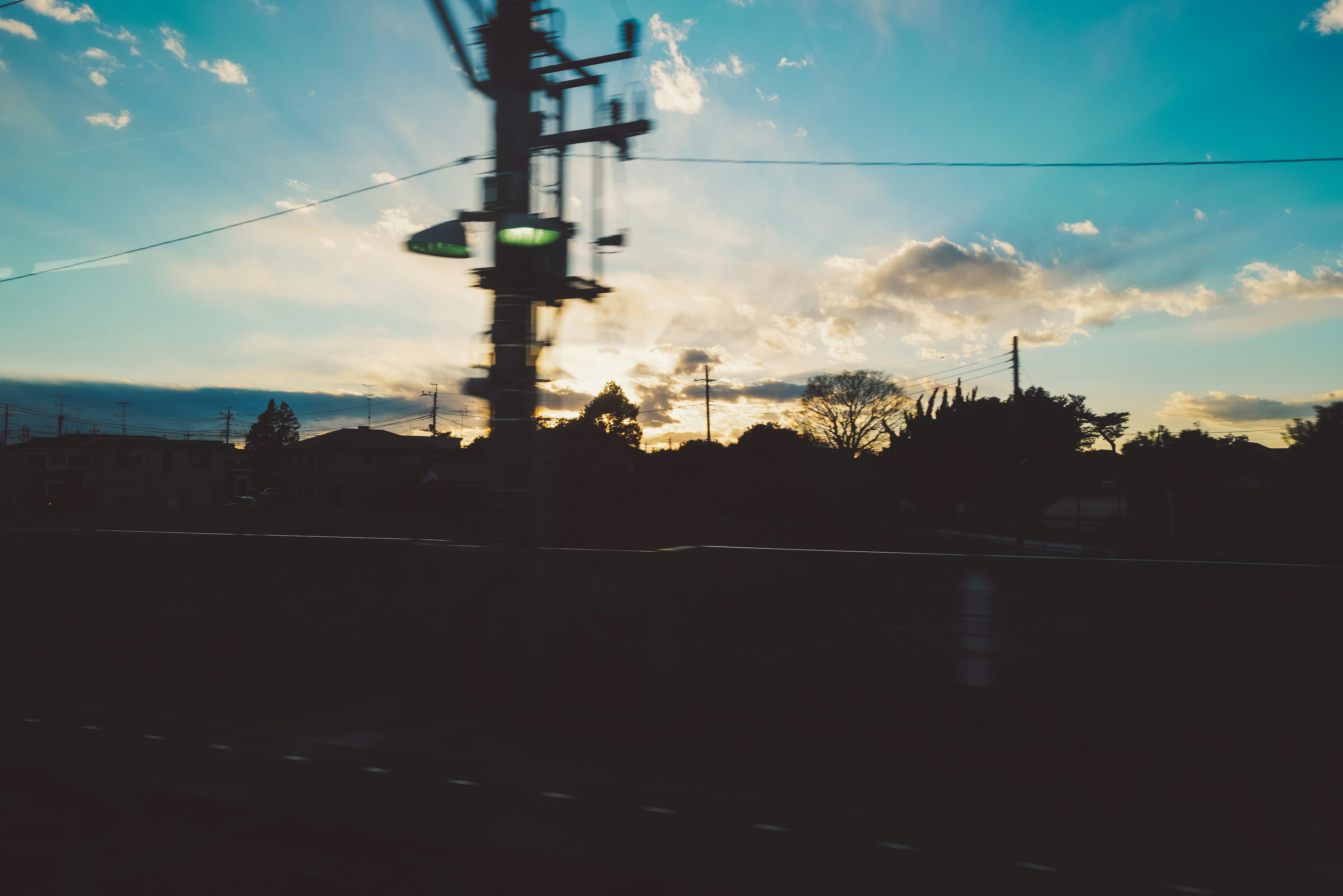 Silhouette of utility poles against a sunset sky