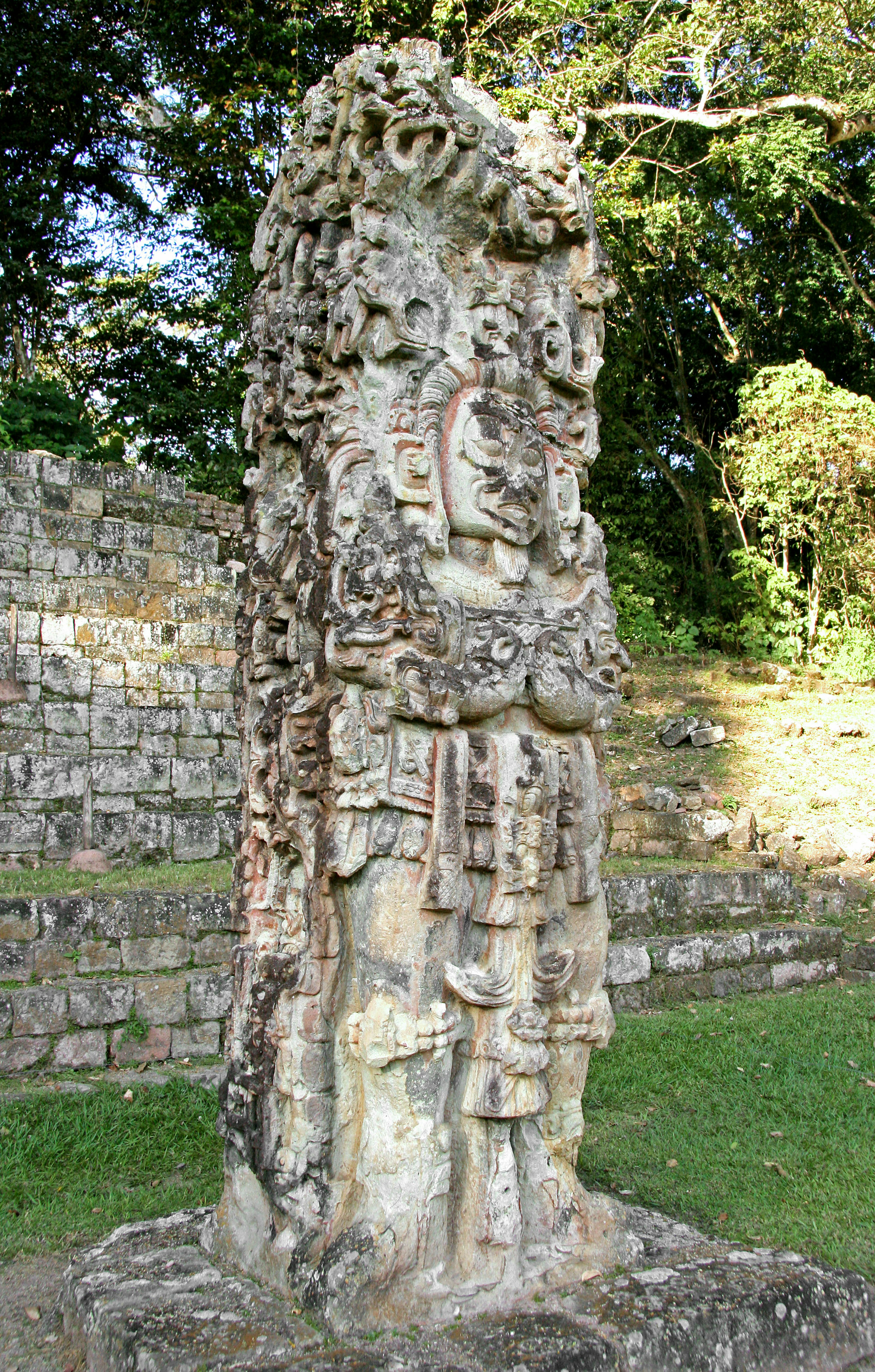 Scultura antica in una rovina con motivi intricati e una figura divina