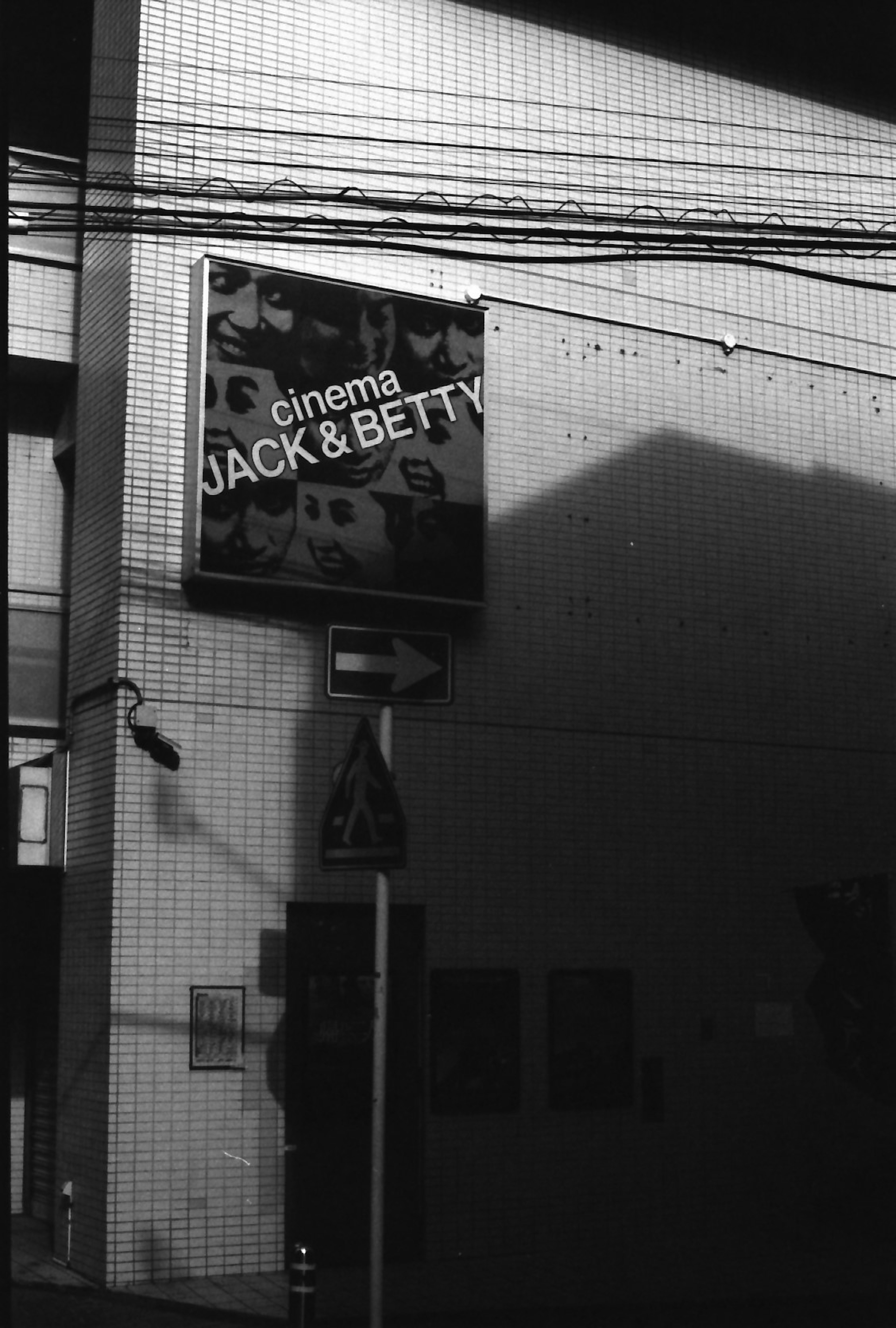 Scène de rue en noir et blanc avec l'enseigne du cinéma Jack & Betty