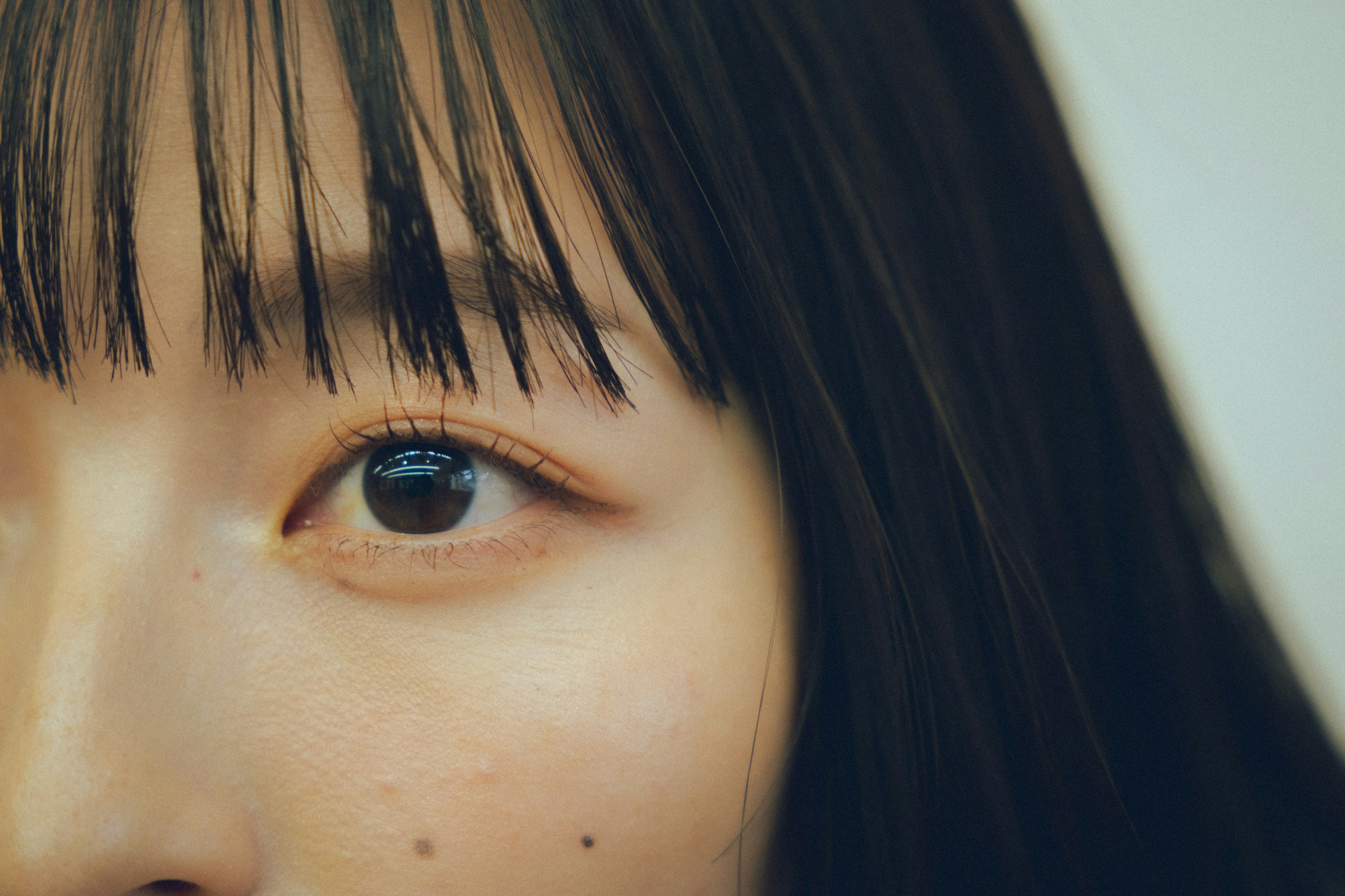 Close-up of a woman's eye featuring delicate eyelashes and natural skin texture