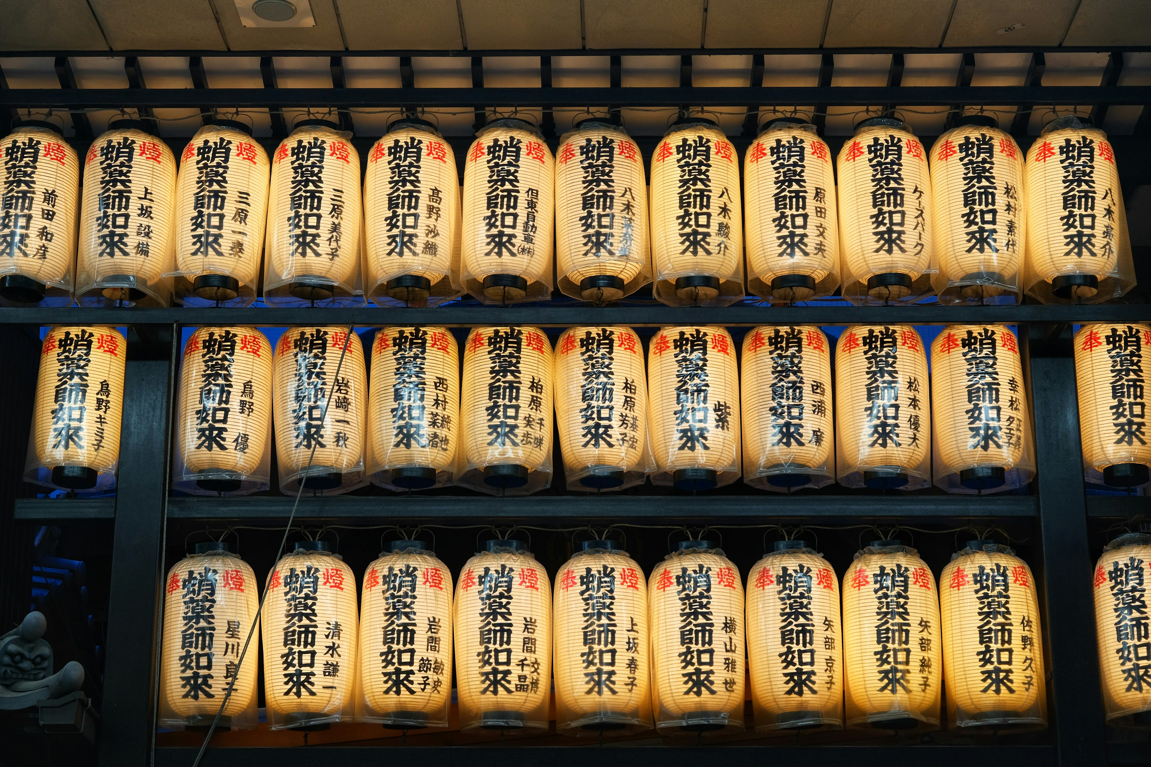 A traditional Japanese scene featuring numerous illuminated paper lanterns