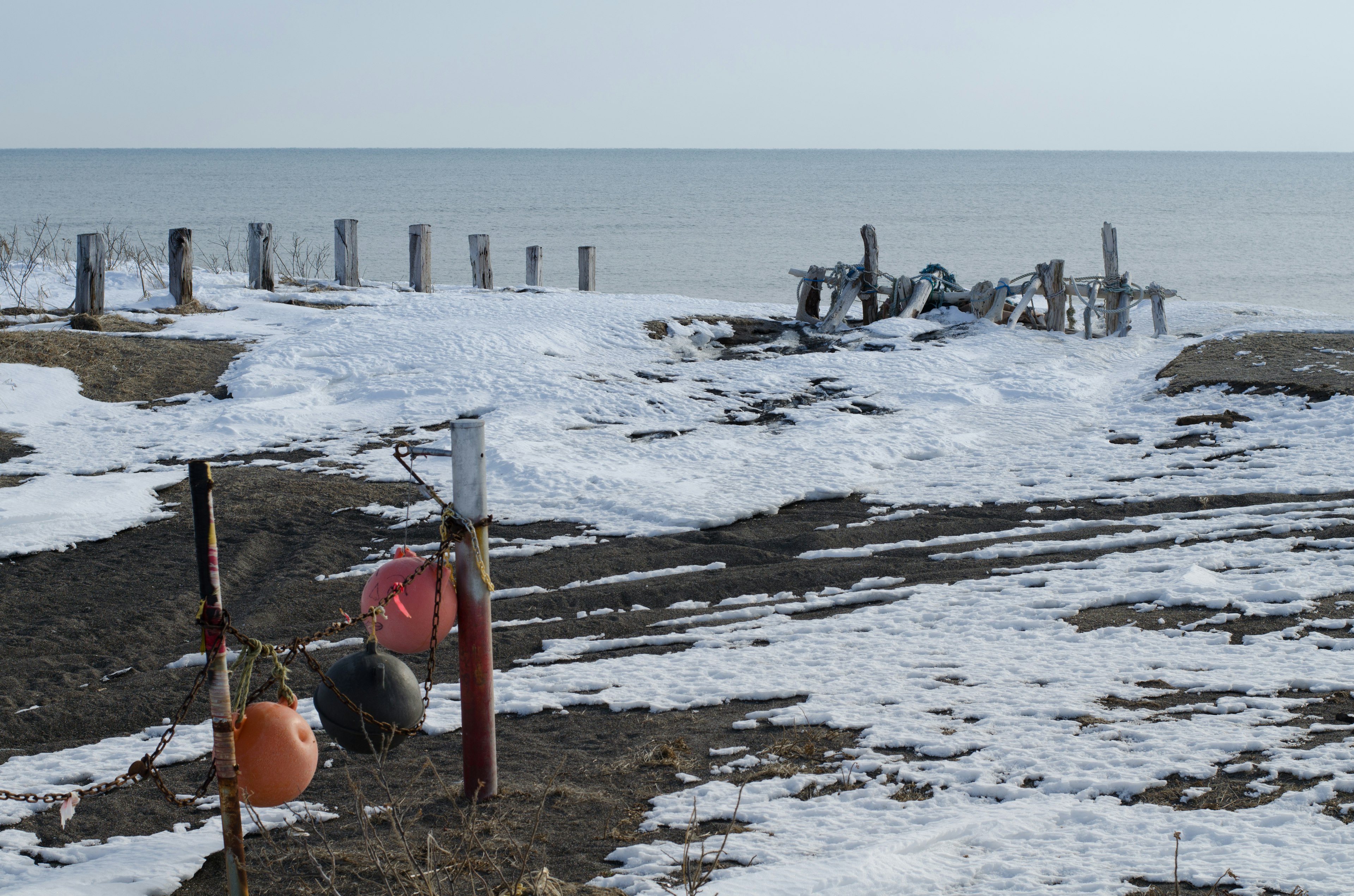 Plage enneigée avec un bouée et un flotteur visibles au premier plan