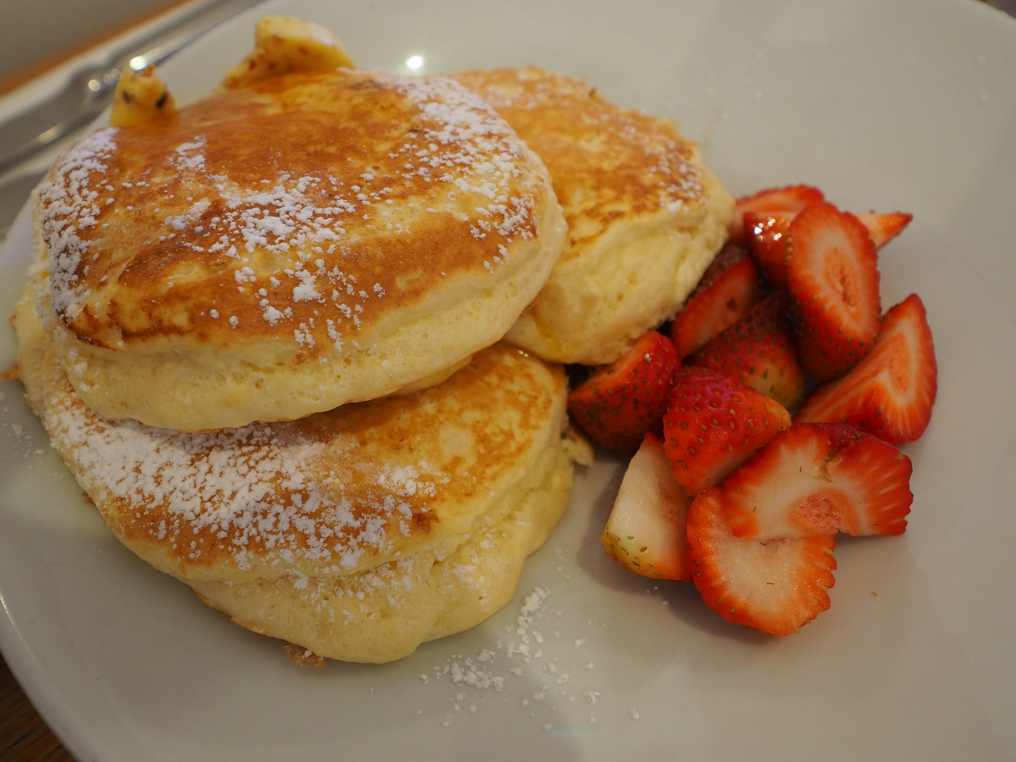 Fluffige Pfannkuchen mit frischen Erdbeeren serviert