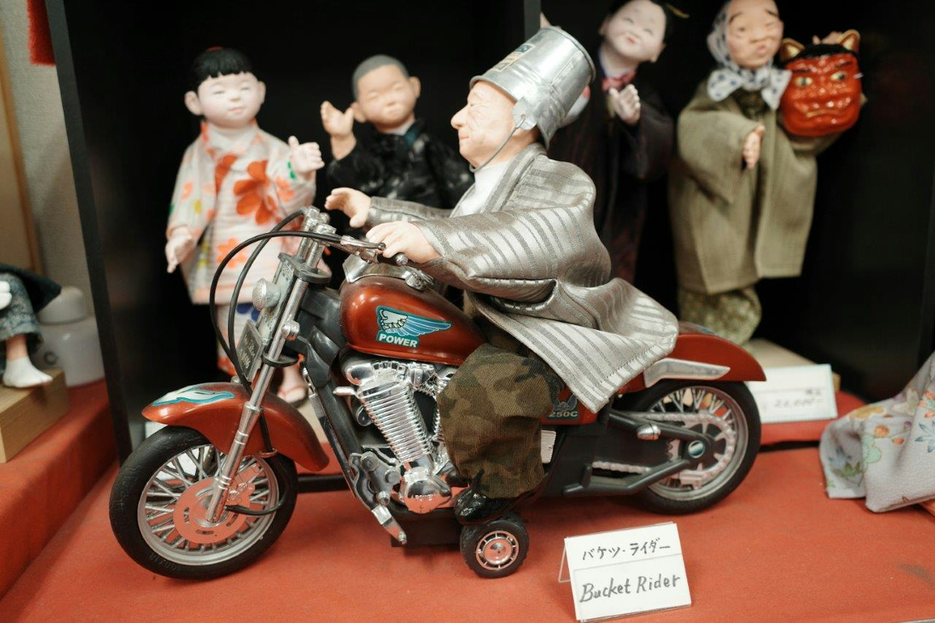 Une figurine sur une moto exposée dans une vitrine