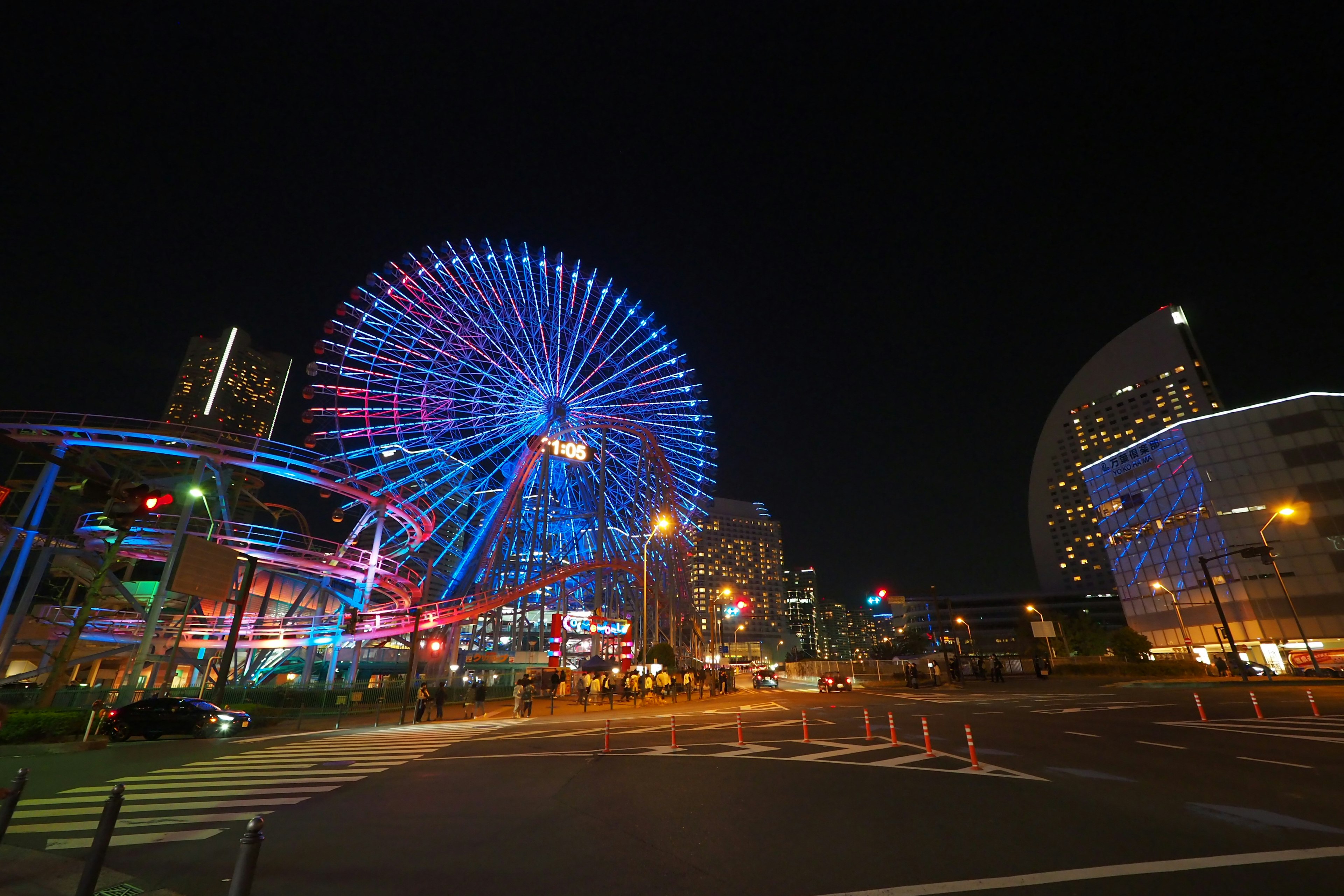 Vue nocturne d'une grande roue colorée et de l'horizon urbain