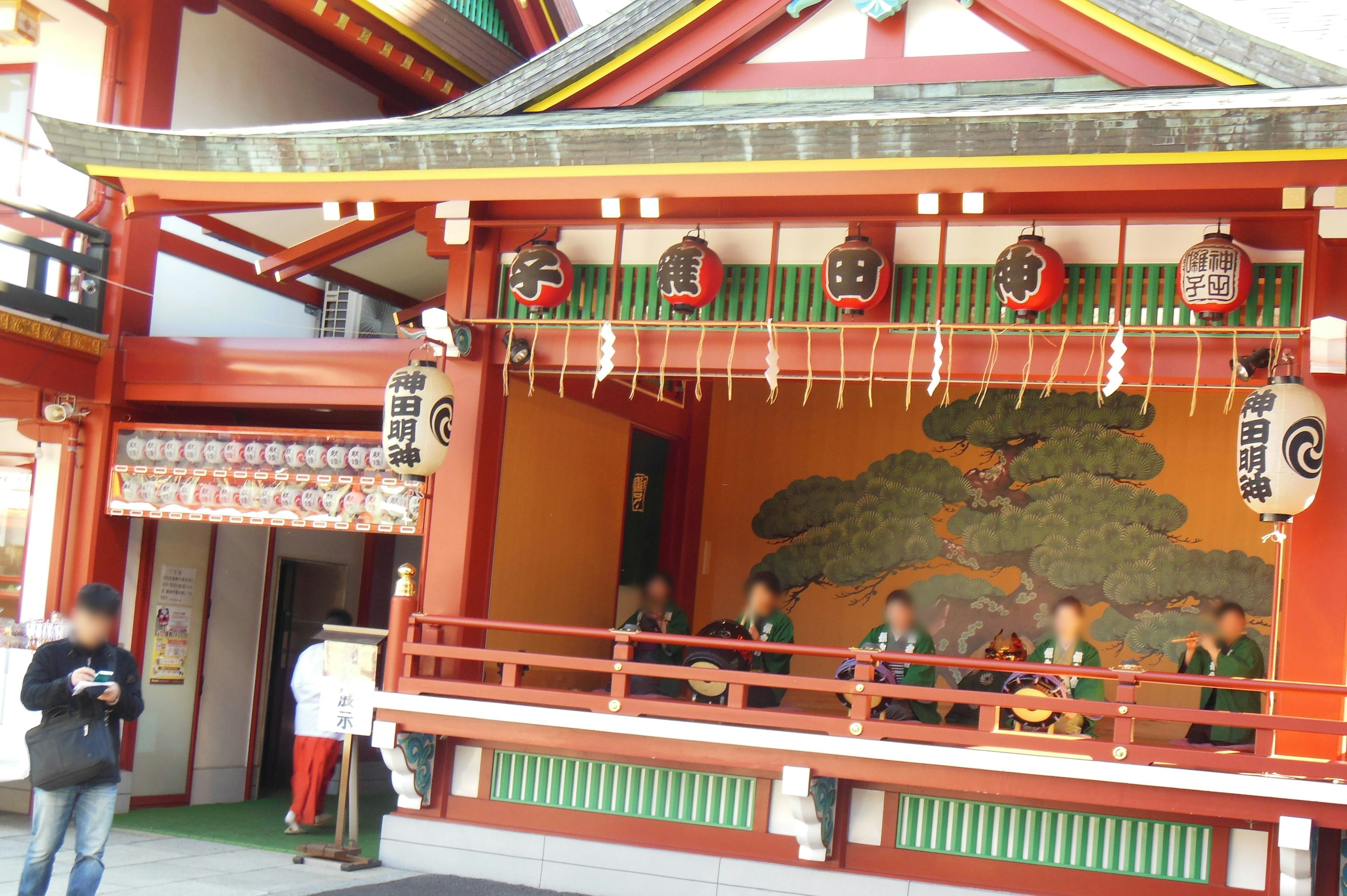 Bâtiment traditionnel japonais coloré avec des artistes sur scène