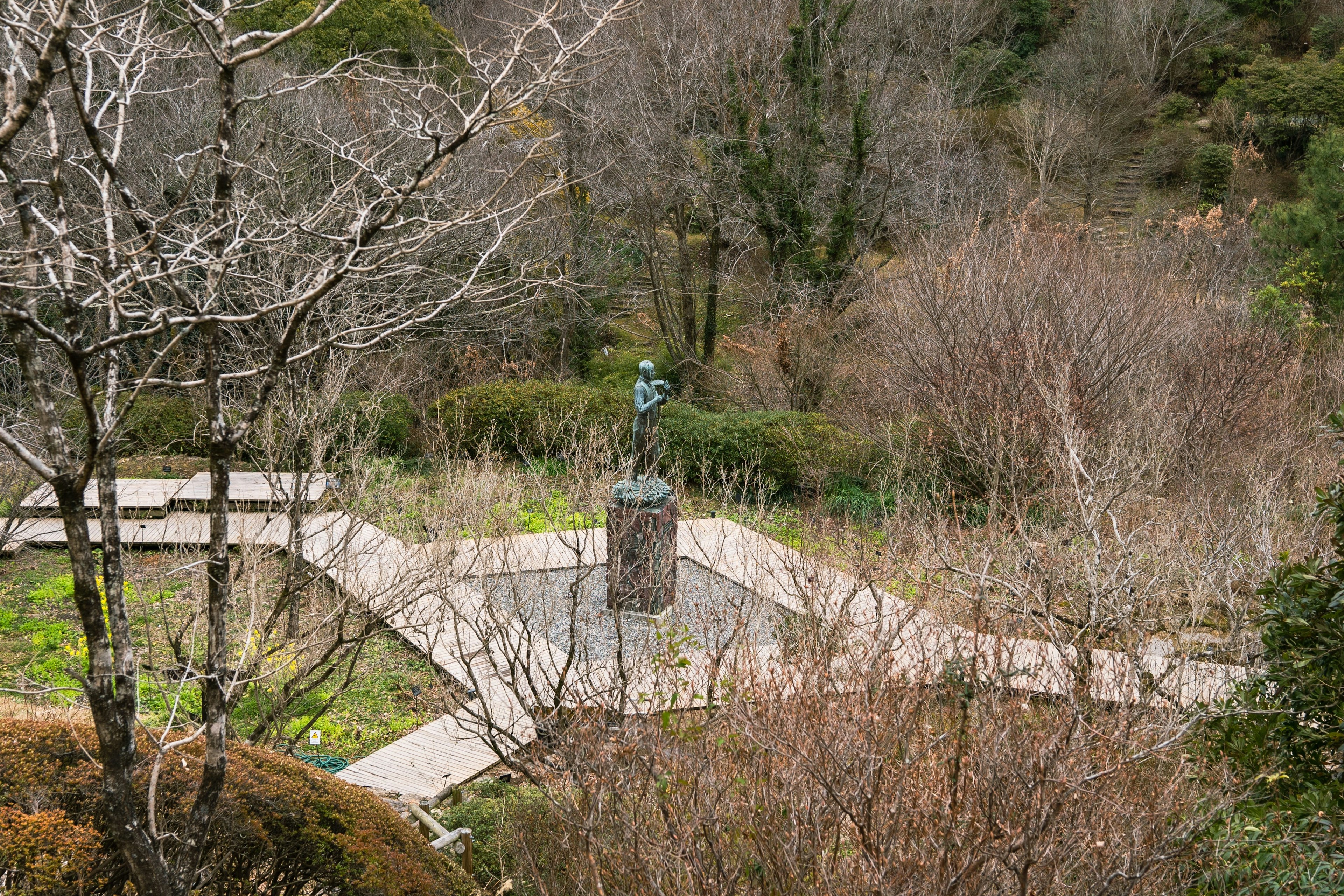 Vista de un parque con una escultura rodeada de árboles