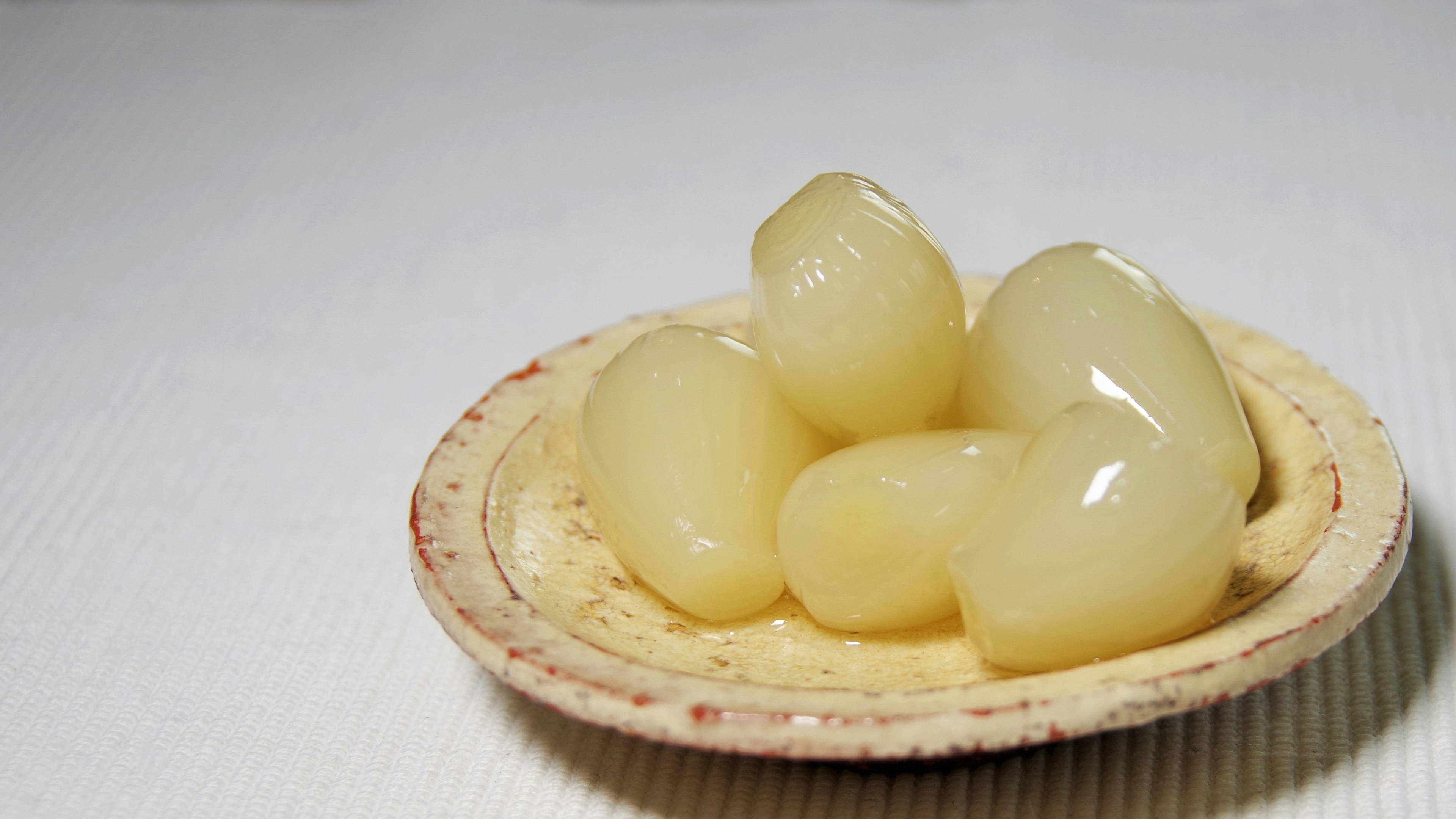 Glossy translucent fruit-like objects on a white plate