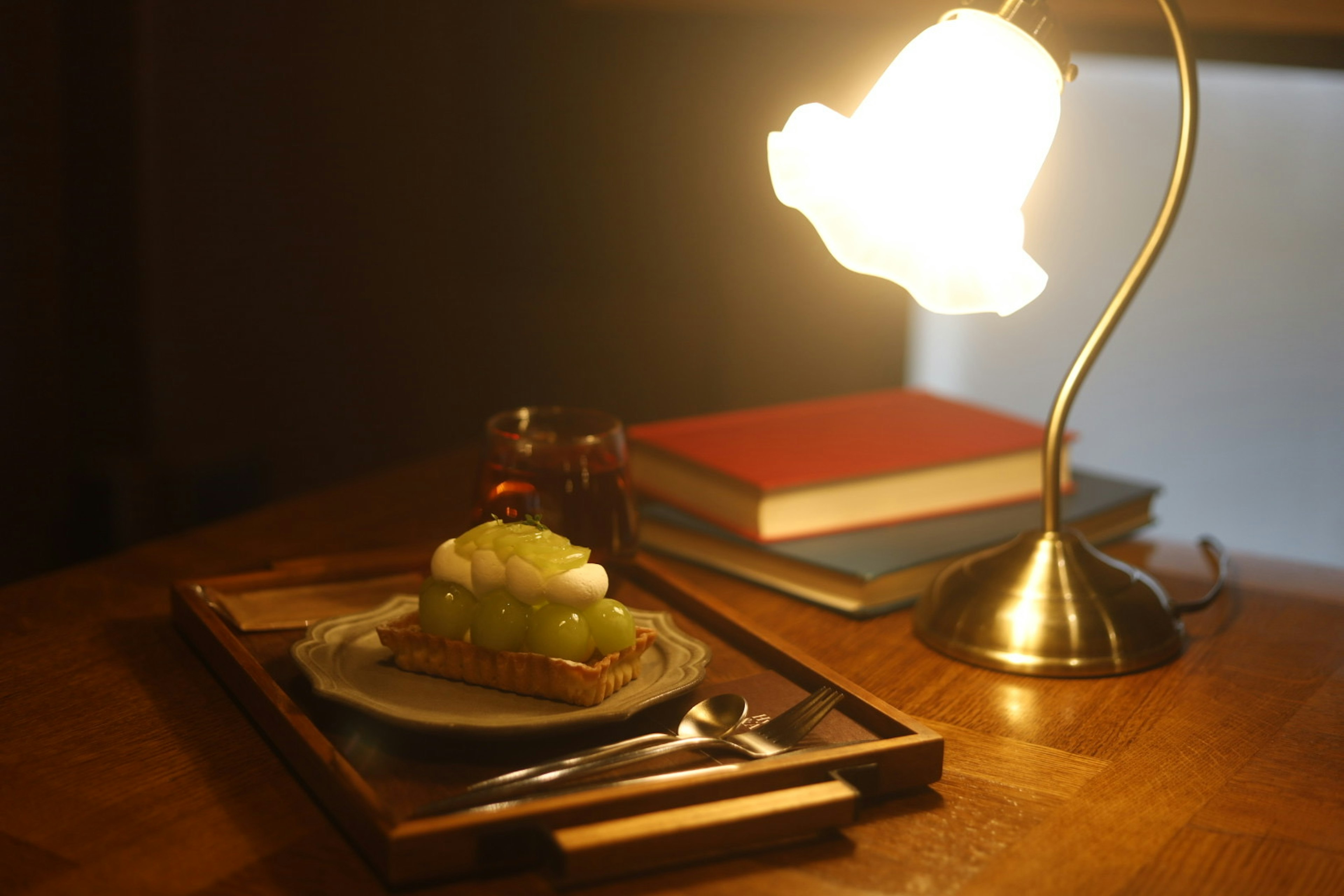 A cozy scene featuring a dessert on a plate and books with warm lighting