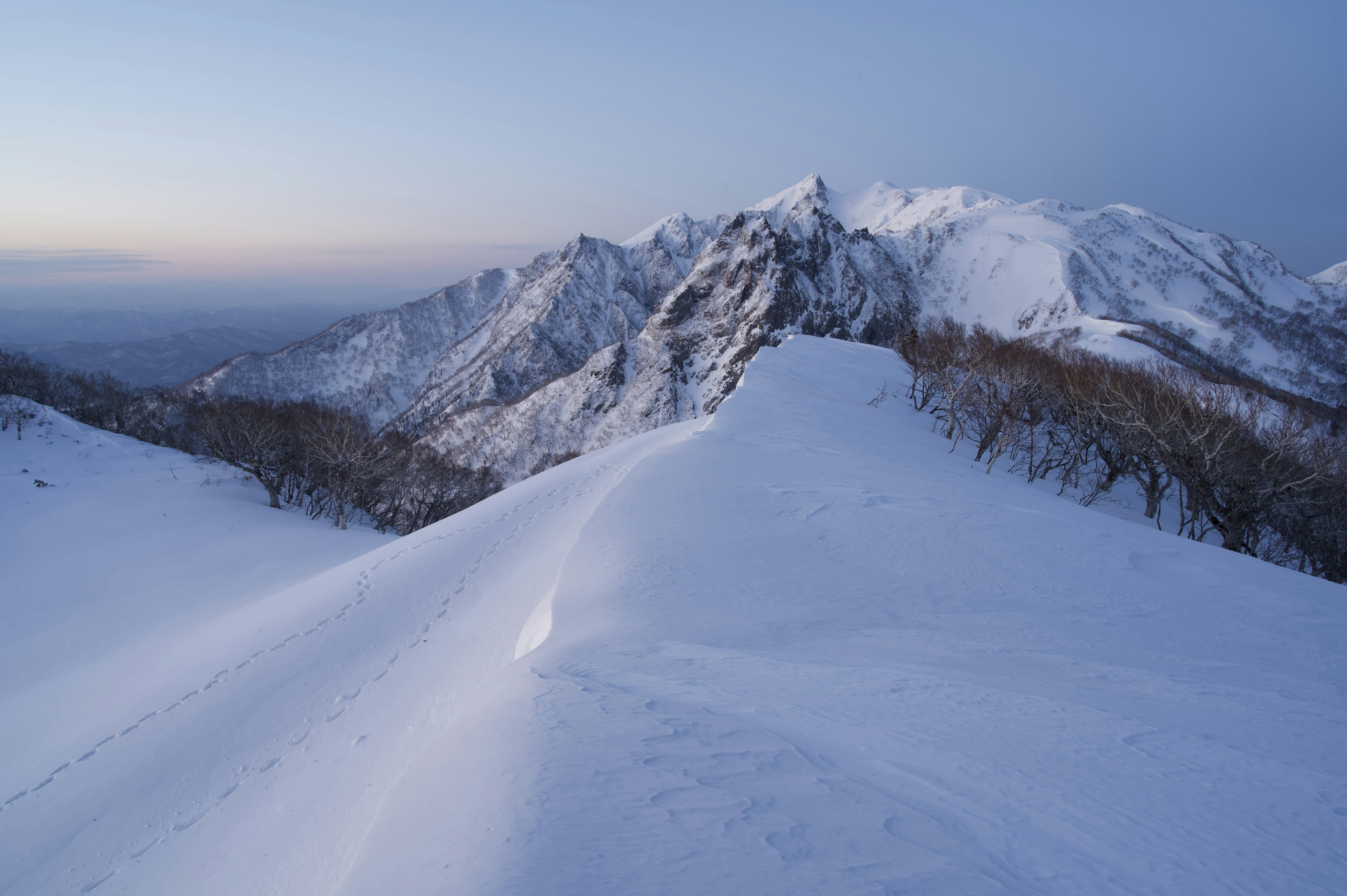 Snow-covered mountain landscape with twilight sky