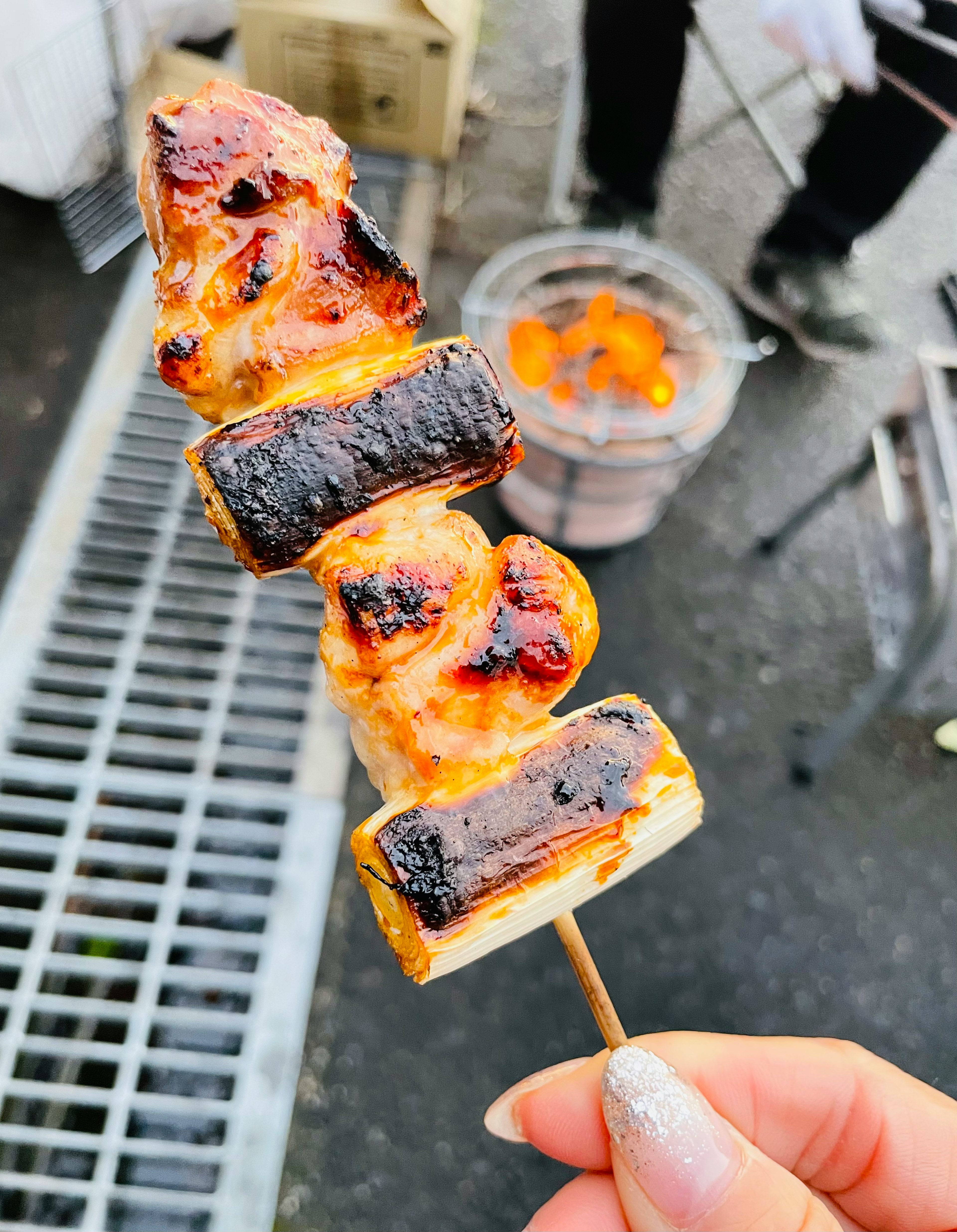 焼き鳥の串焼きが手に持たれている