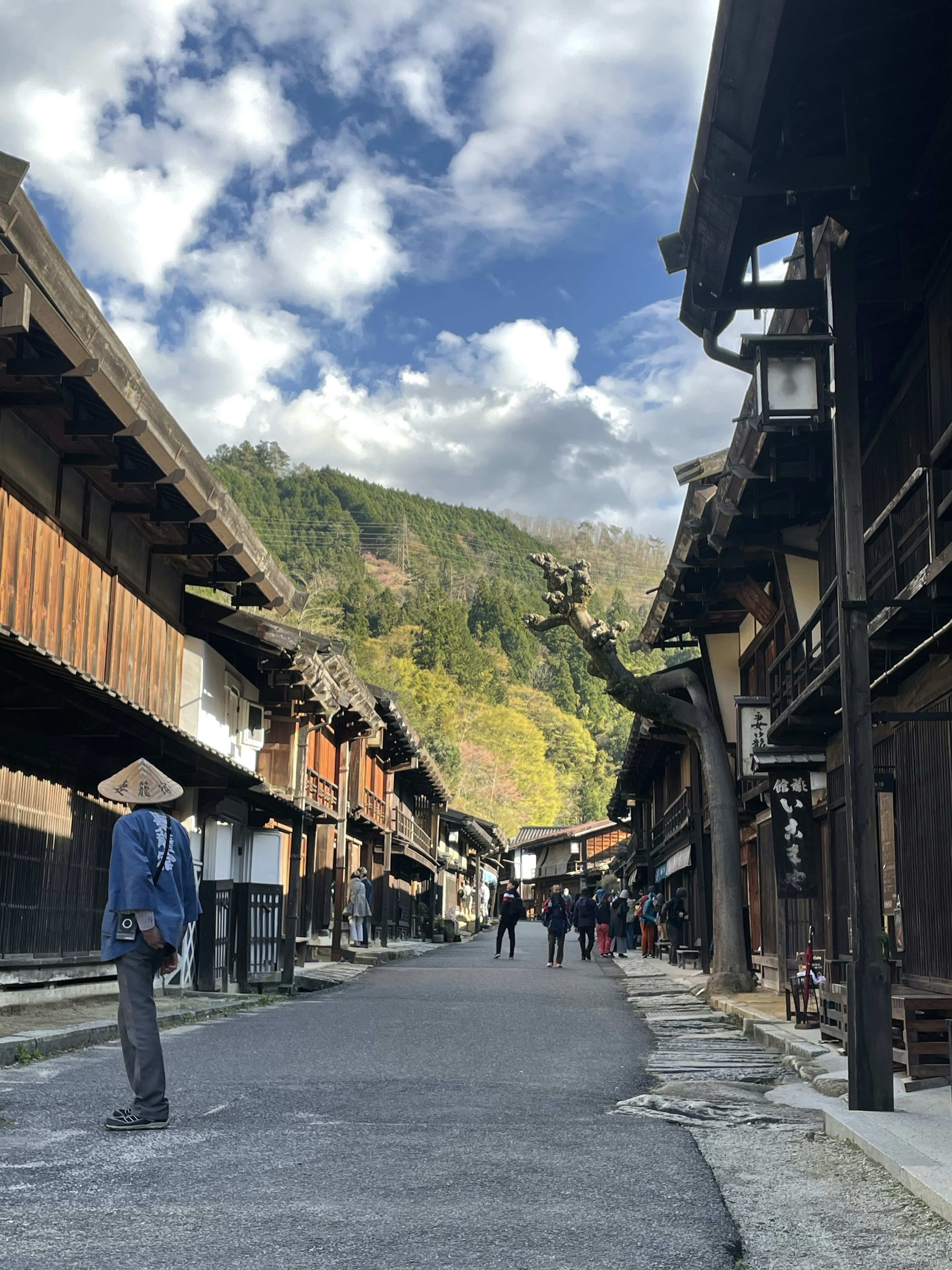 Calle histórica con edificios de madera tradicionales y fondo montañoso