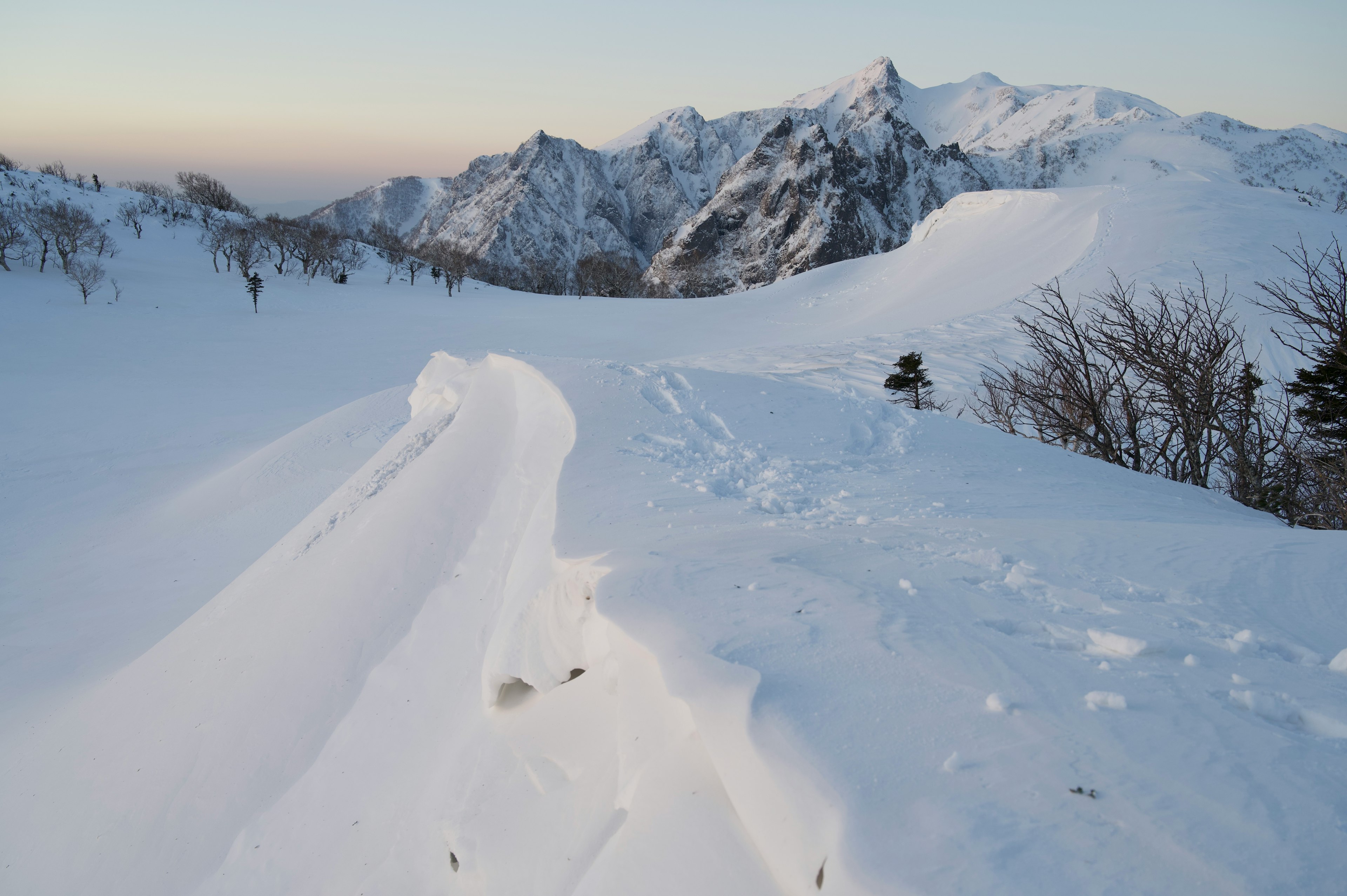 被雪覆盖的山景，蜿蜒的白色小路和脚印