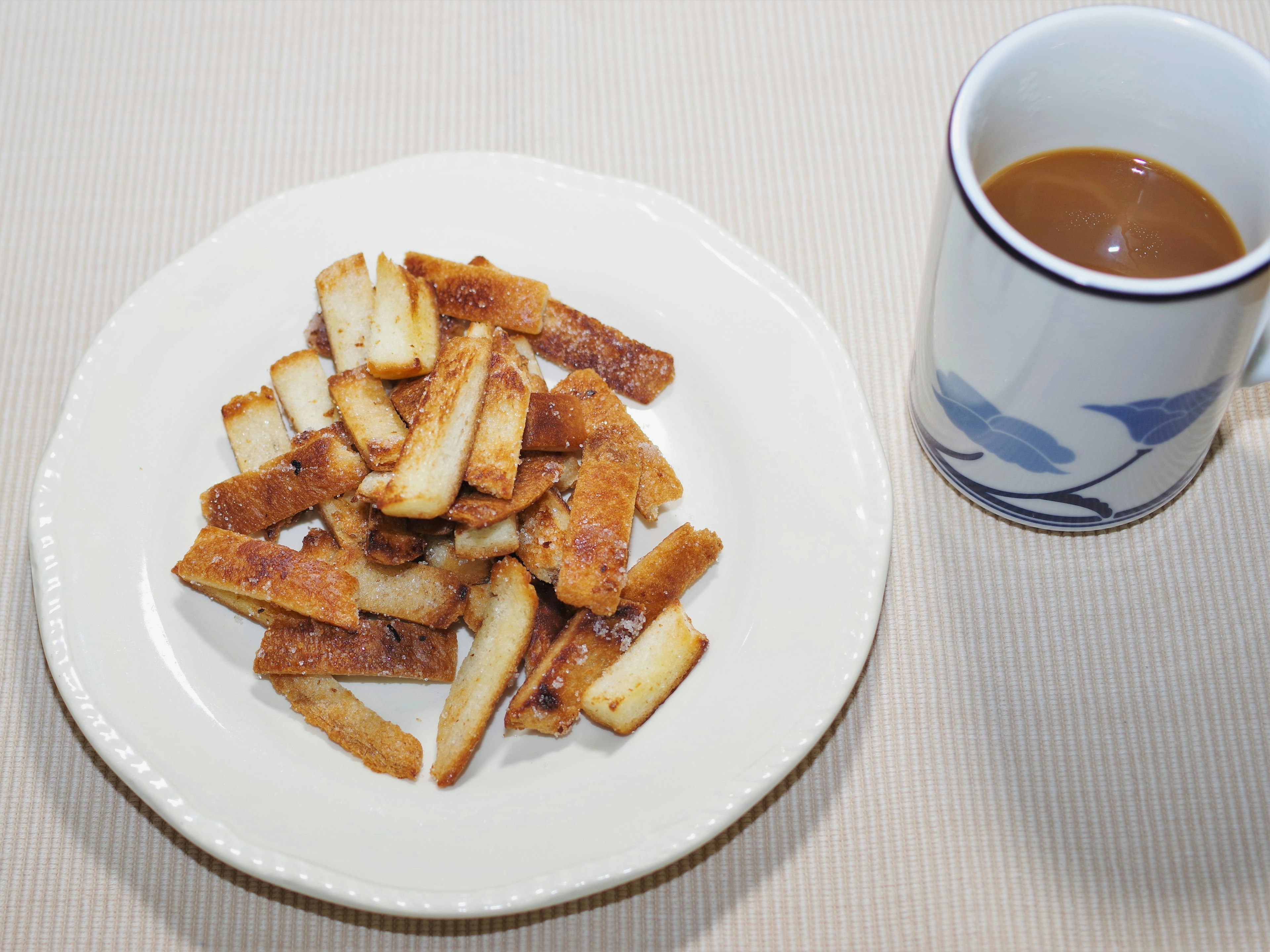 Camilan goreng di atas piring dengan secangkir kopi