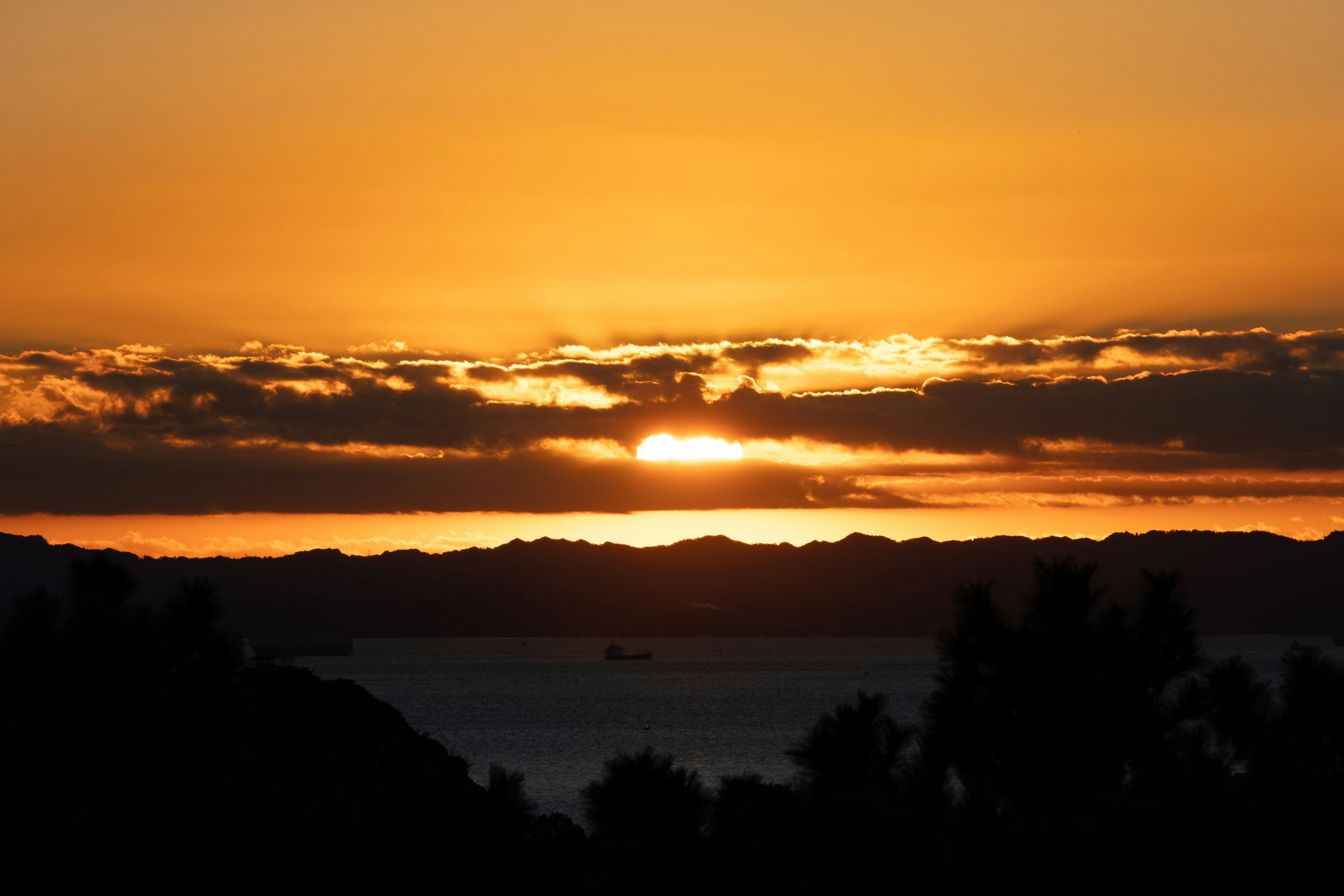 美しい夕日が水平線に沈む風景 様々なオレンジ色の空と雲が広がる