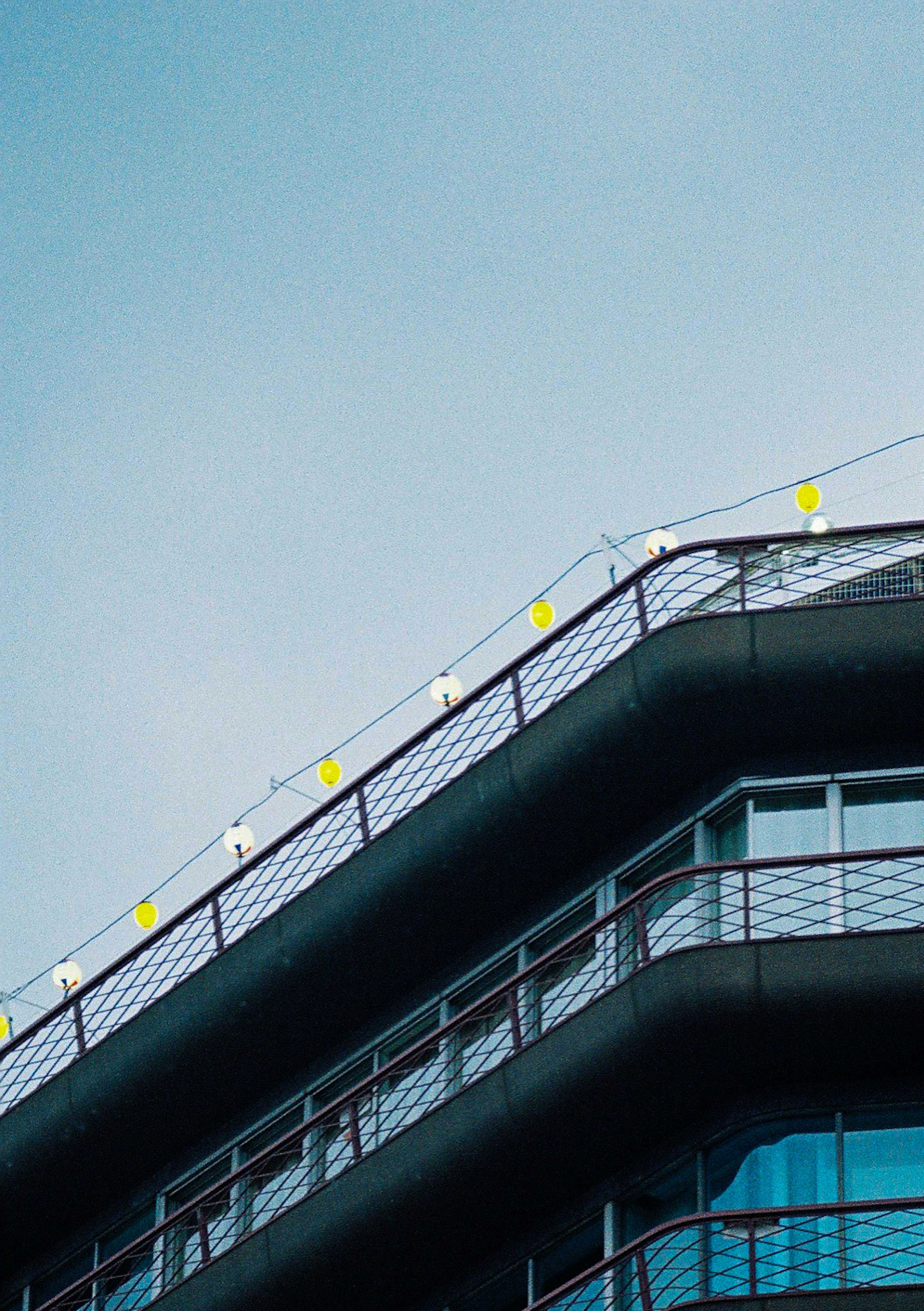 Modern building rooftop adorned with decorative lights under a blue sky