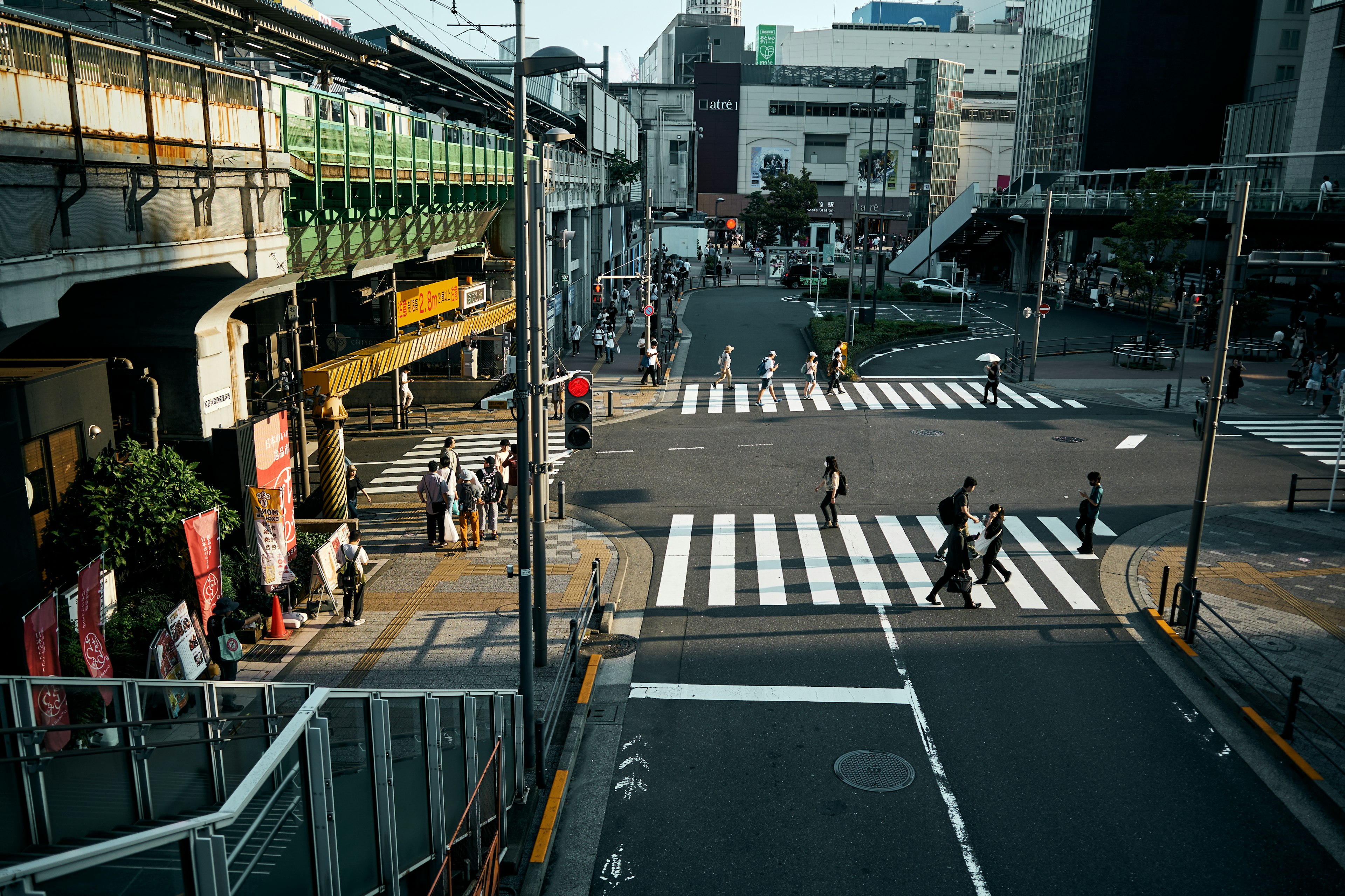 交差点に多くの歩行者と電車が見える風景