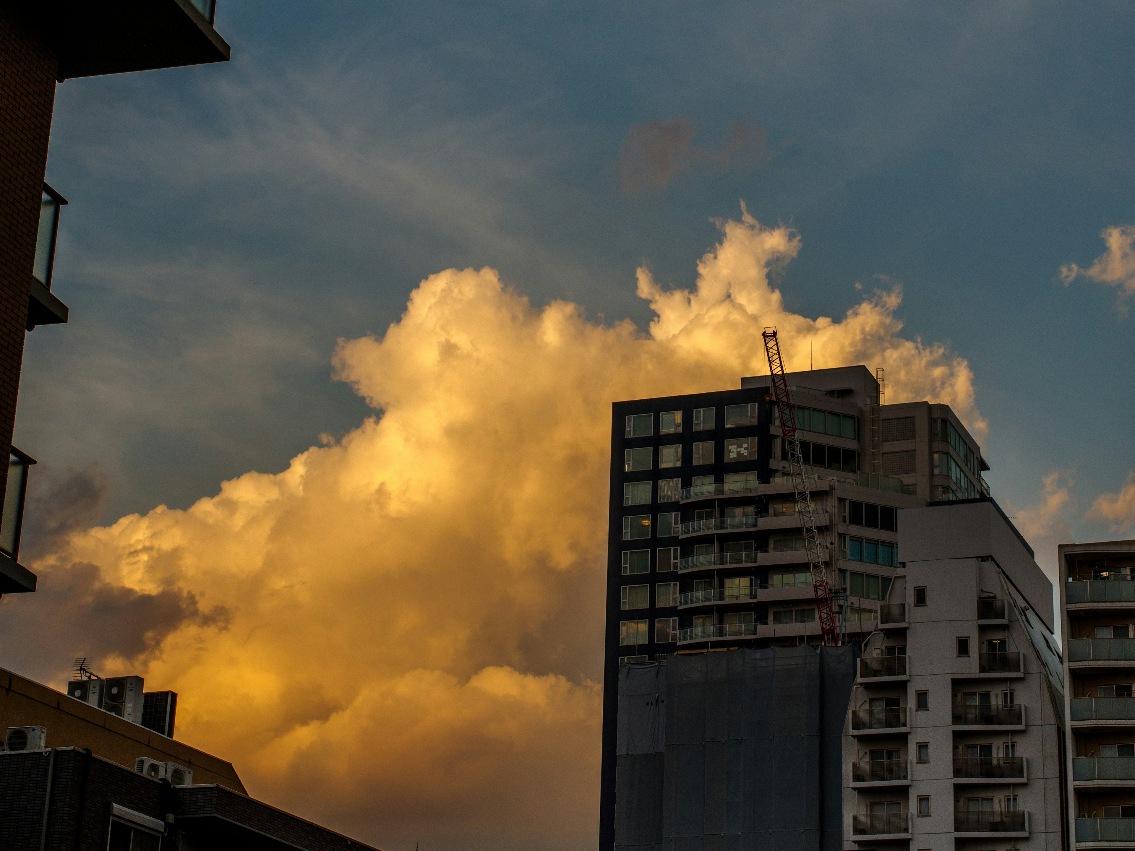 Silhouette d'un gratte-ciel avec des nuages illuminés au coucher du soleil